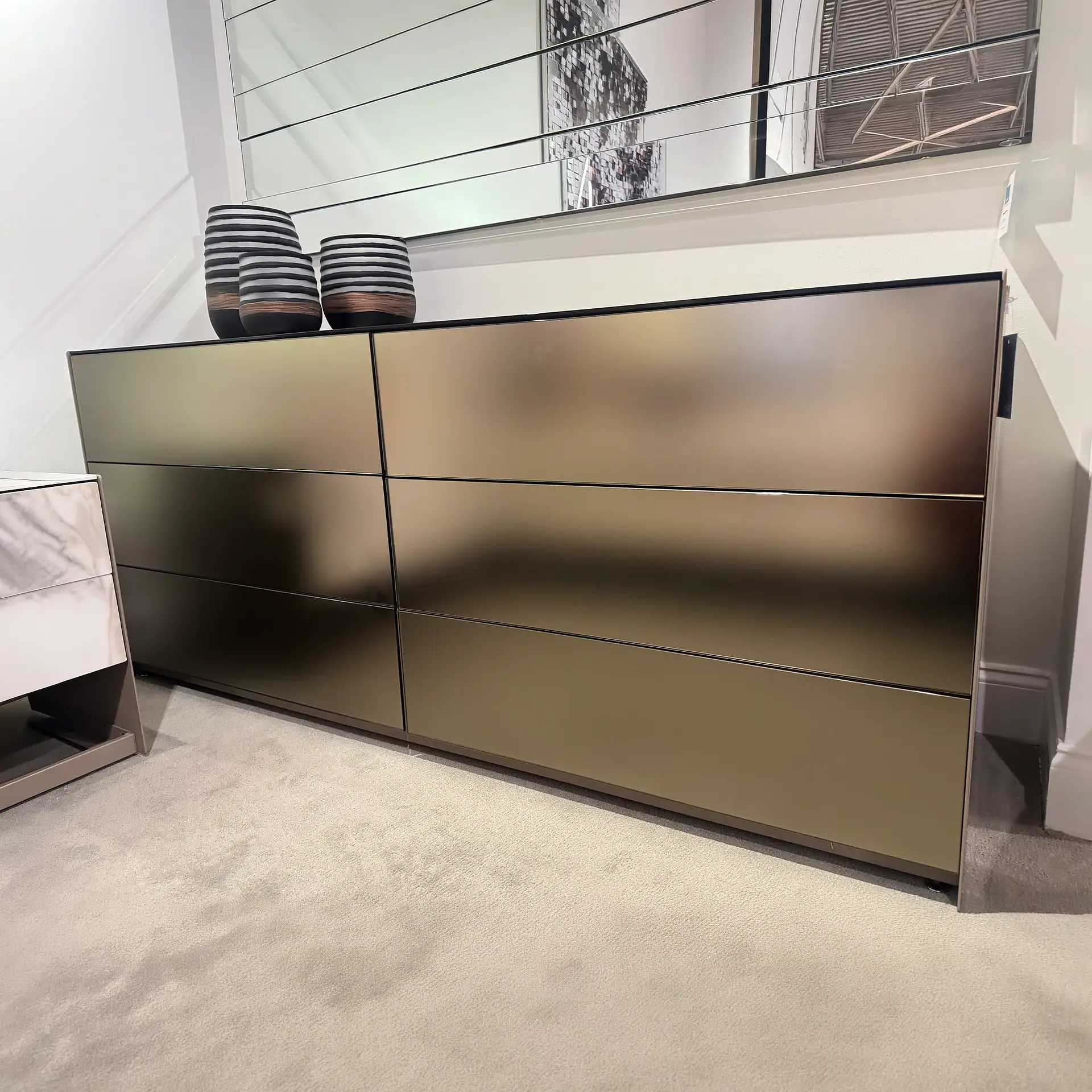 Sleek modern dresser with six drawers in a contemporary room setting.