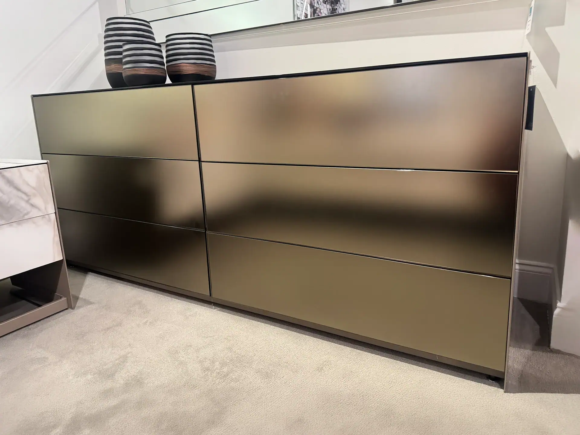 Modern six-drawer dresser with sleek metallic finish in a contemporary setting.