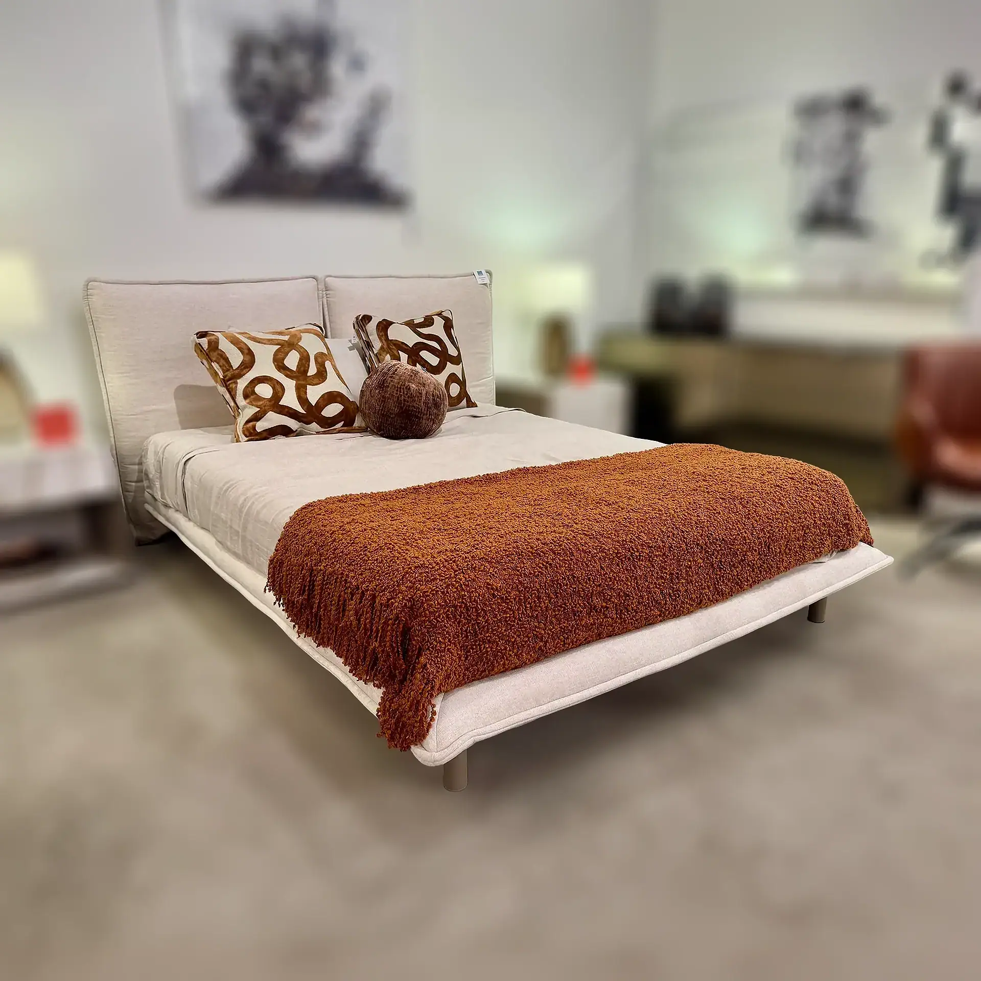 Haven Queen Bed by Trica with decorative pillows and rust-colored throw blanket.