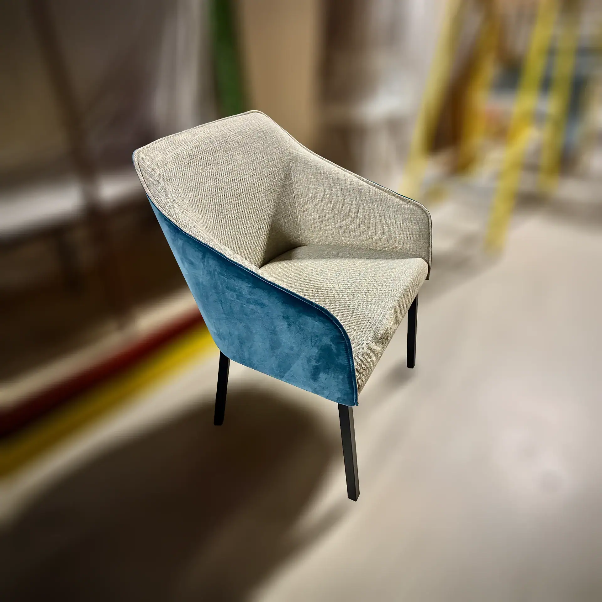 Modern dining chair with beige and blue upholstery and black legs.