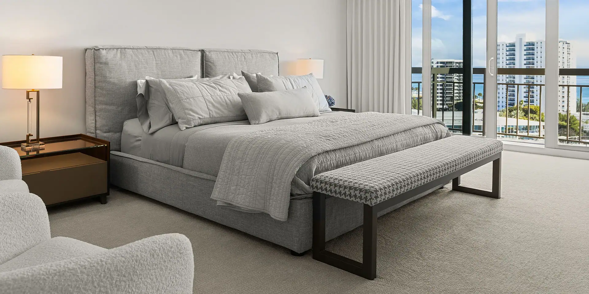 Gray upholstered bed with matching bench in a contemporary bedroom setting.