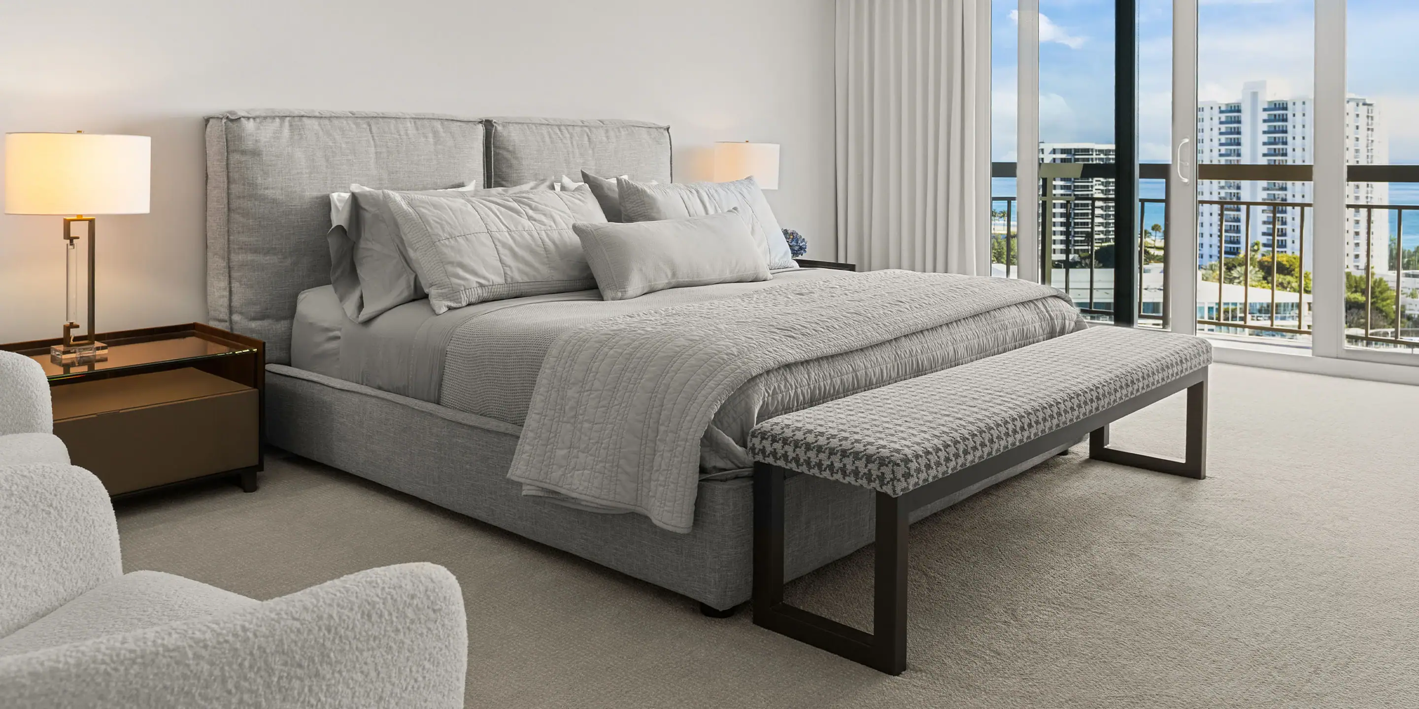 Gray upholstered bed with matching bench in a contemporary bedroom setting.