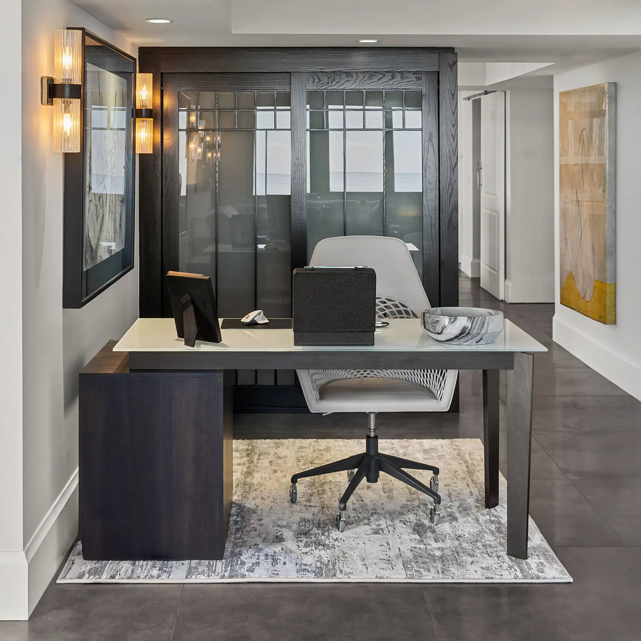 Office desk with computer, chair, and decorative elements in a contemporary setting.