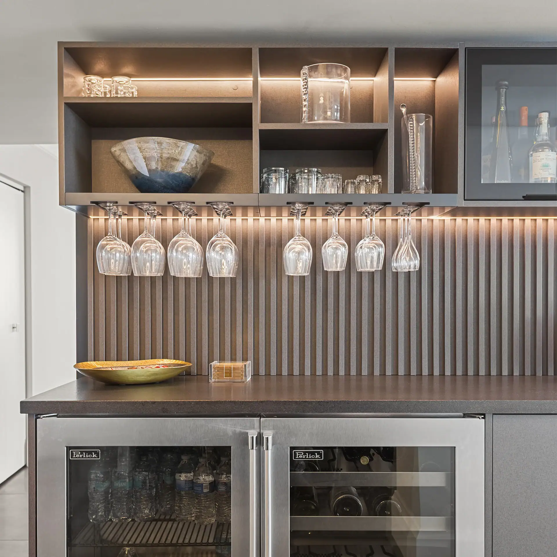 Contemporary kitchen bar with hanging glassware and stylish shelving.