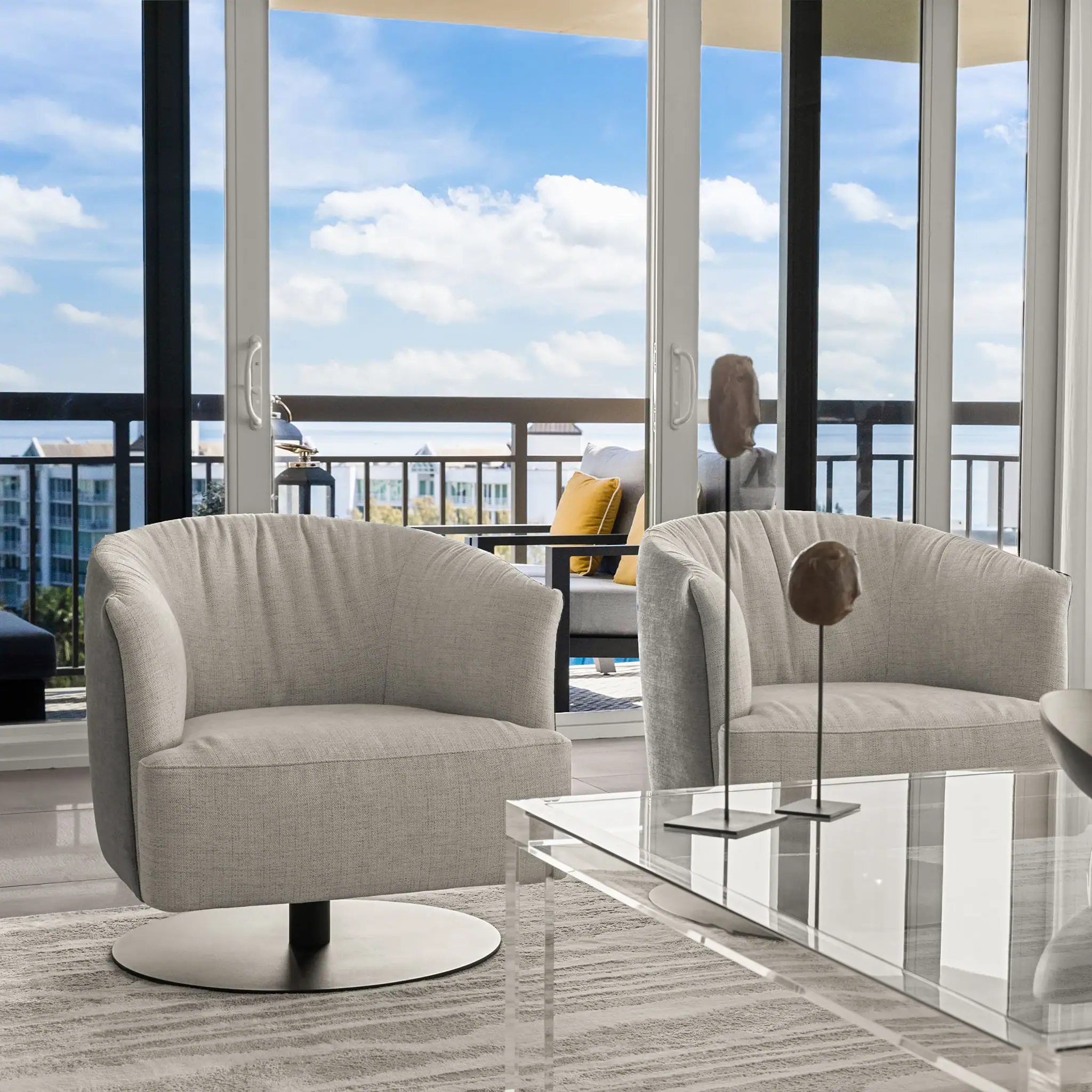 Contemporary living room with stylish furniture and panoramic city view from large windows.