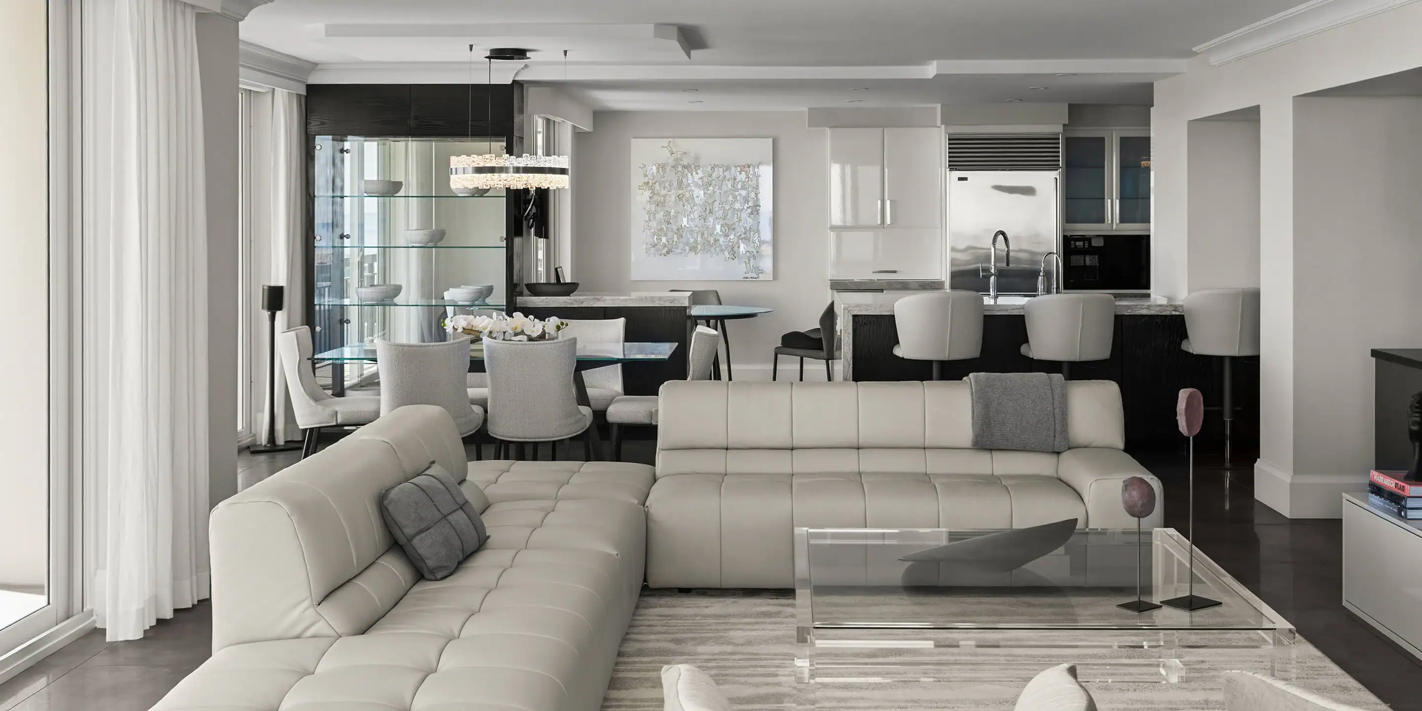Modern white living room with open kitchen and dining space, featuring contemporary furniture and st.