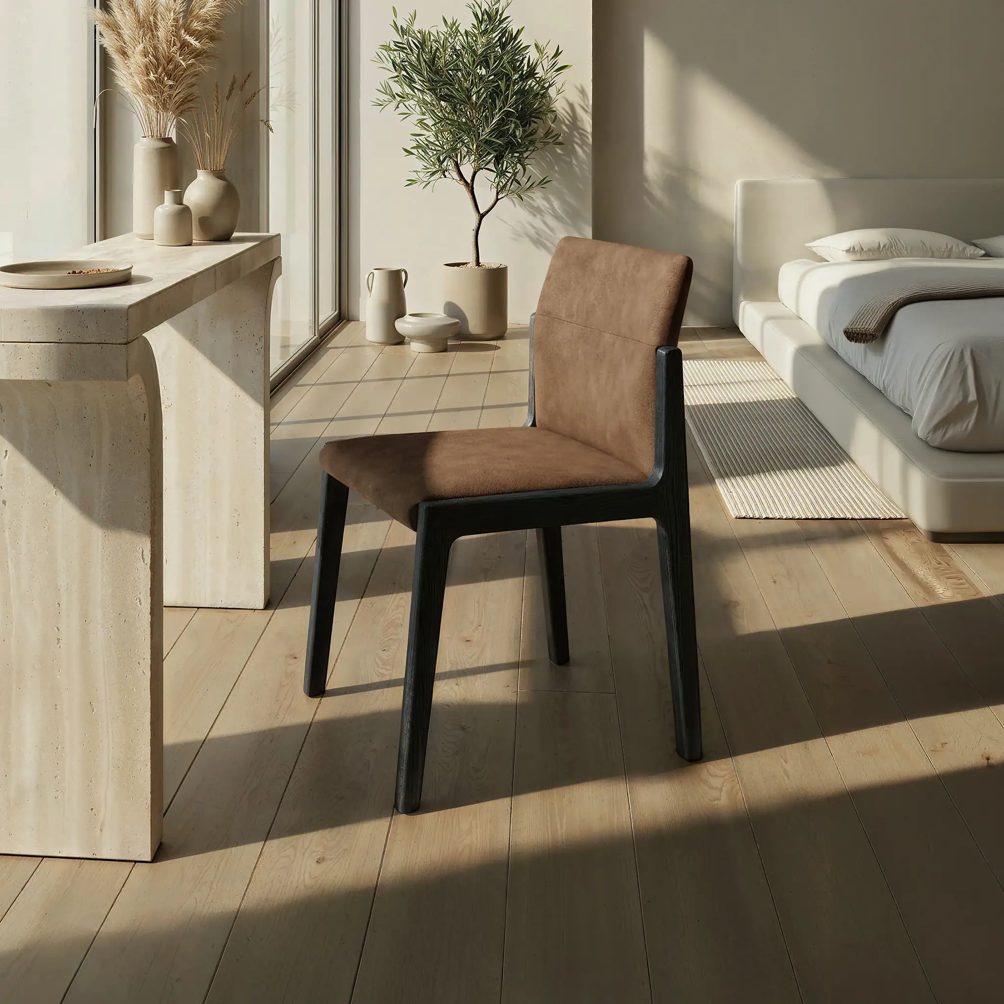Modern dining chair with brown upholstery and black wooden legs in a bright room.