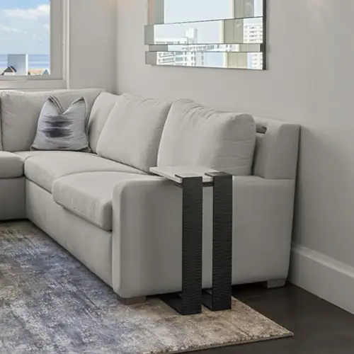 Elegant white sofa with a sleek black side table in a contemporary living room setting.