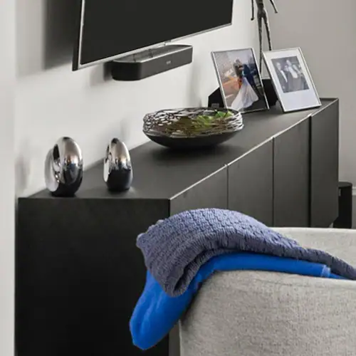 Modern living room with black media console, decorative vases, and framed photos for stylish home de.