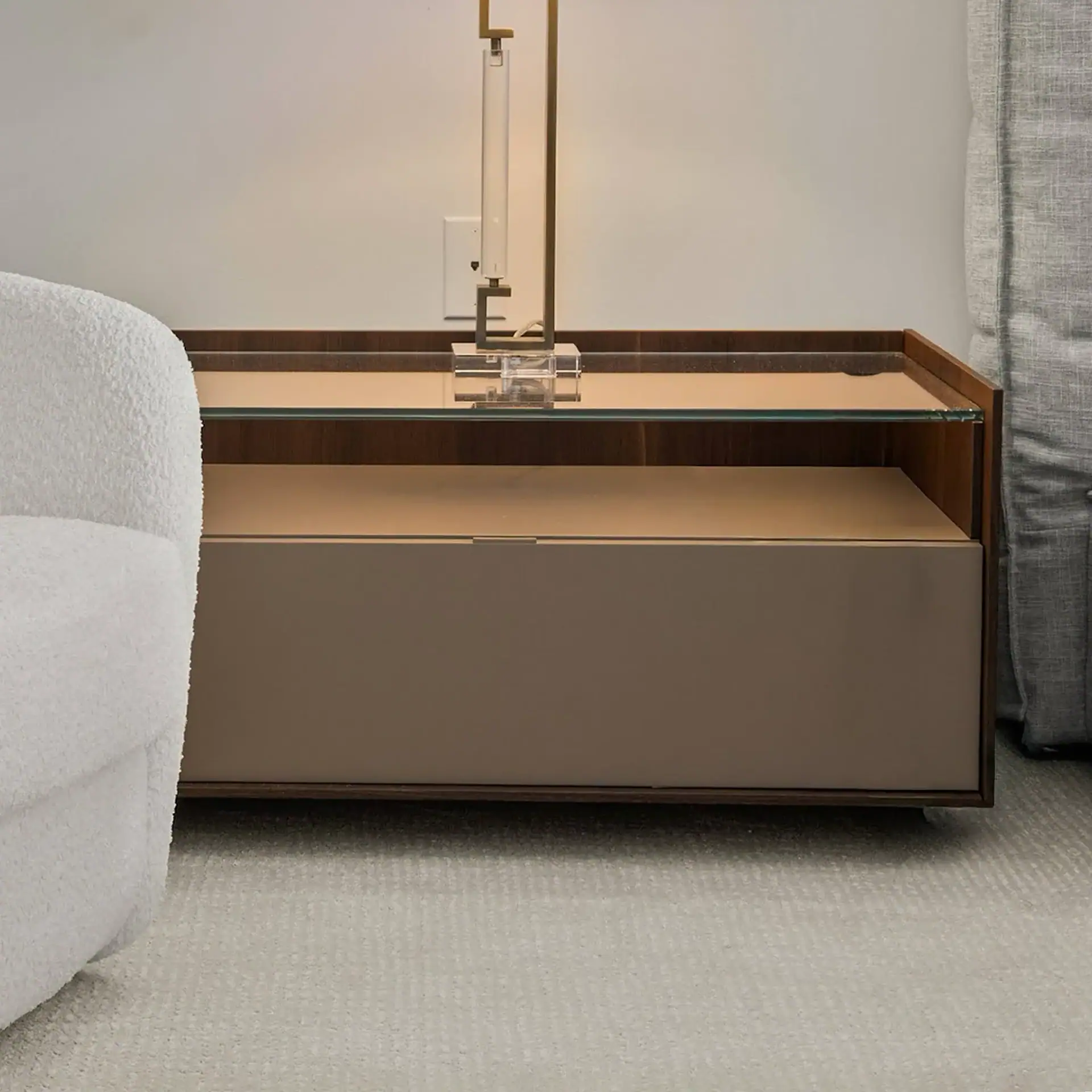Modern minimalist side table with glass top and wooden accents.