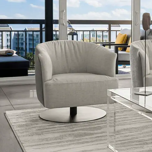 Beige swivel lounge chair with rounded backrest in a contemporary living room setting with city skyl.