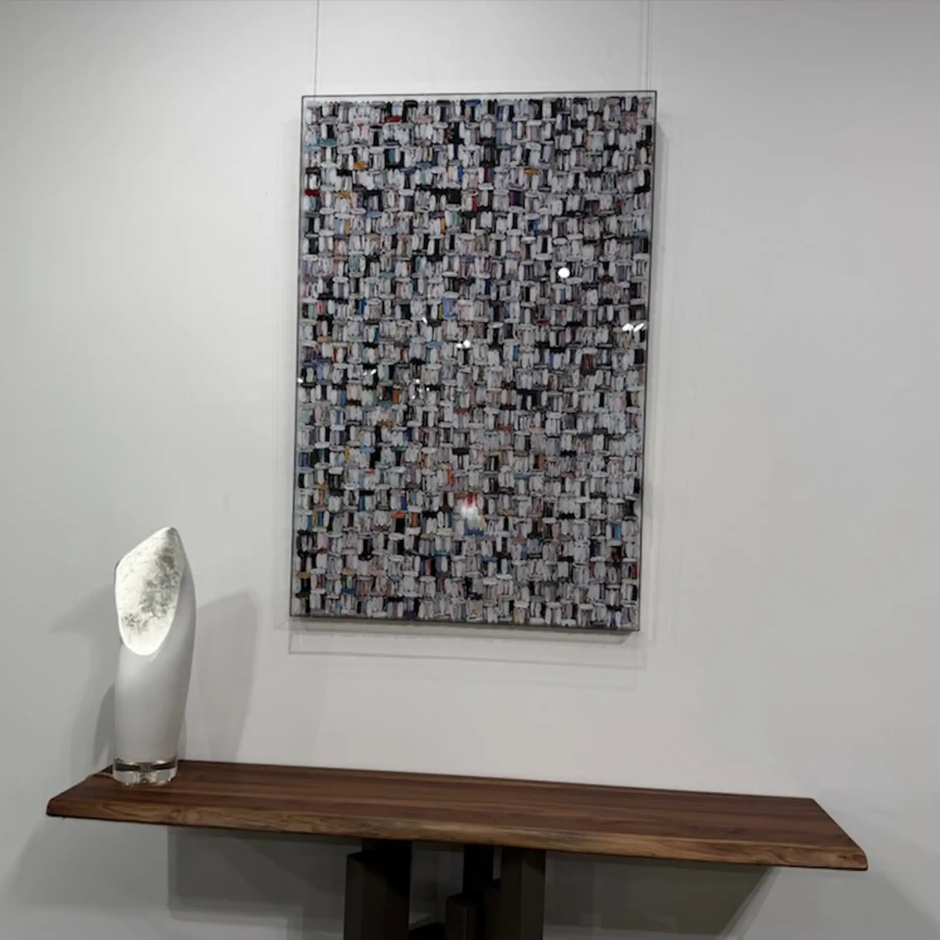 Elegant abstract wall art with textured mosaic design, displayed above a sleek wooden console table.