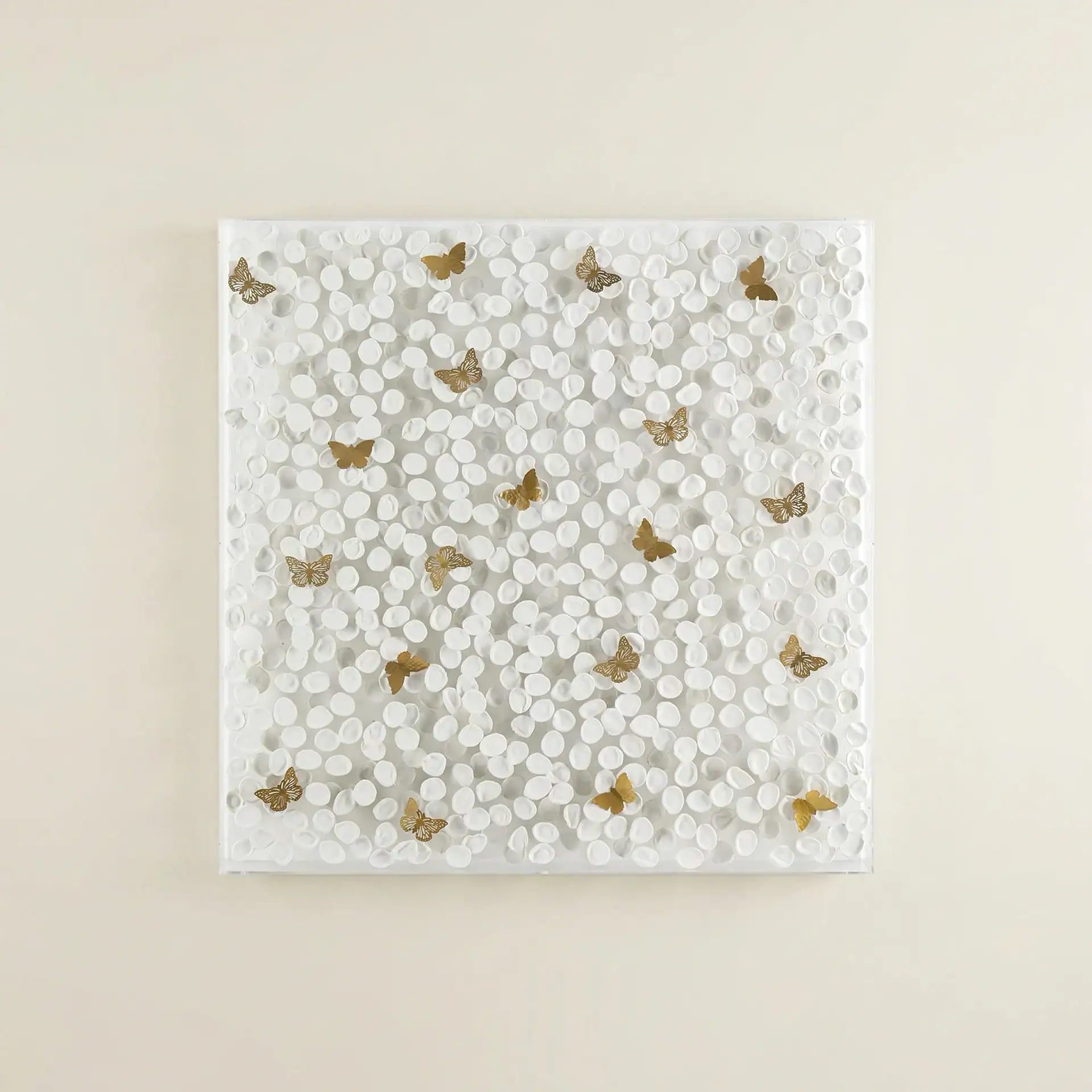 White wall art with gold butterfly accents and circular patterns.