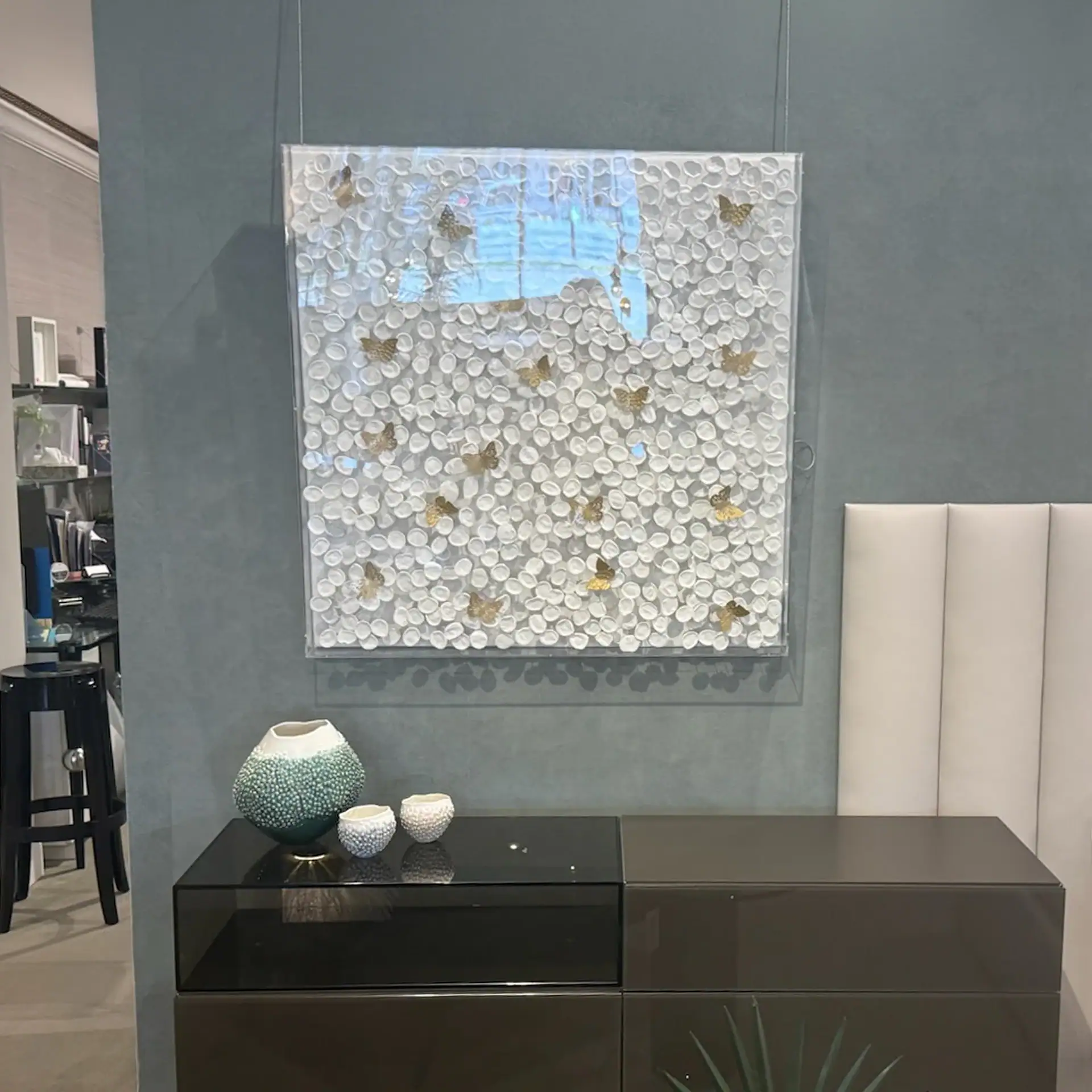 Contemporary wall art with white and gold accents in a stylish interior setting.