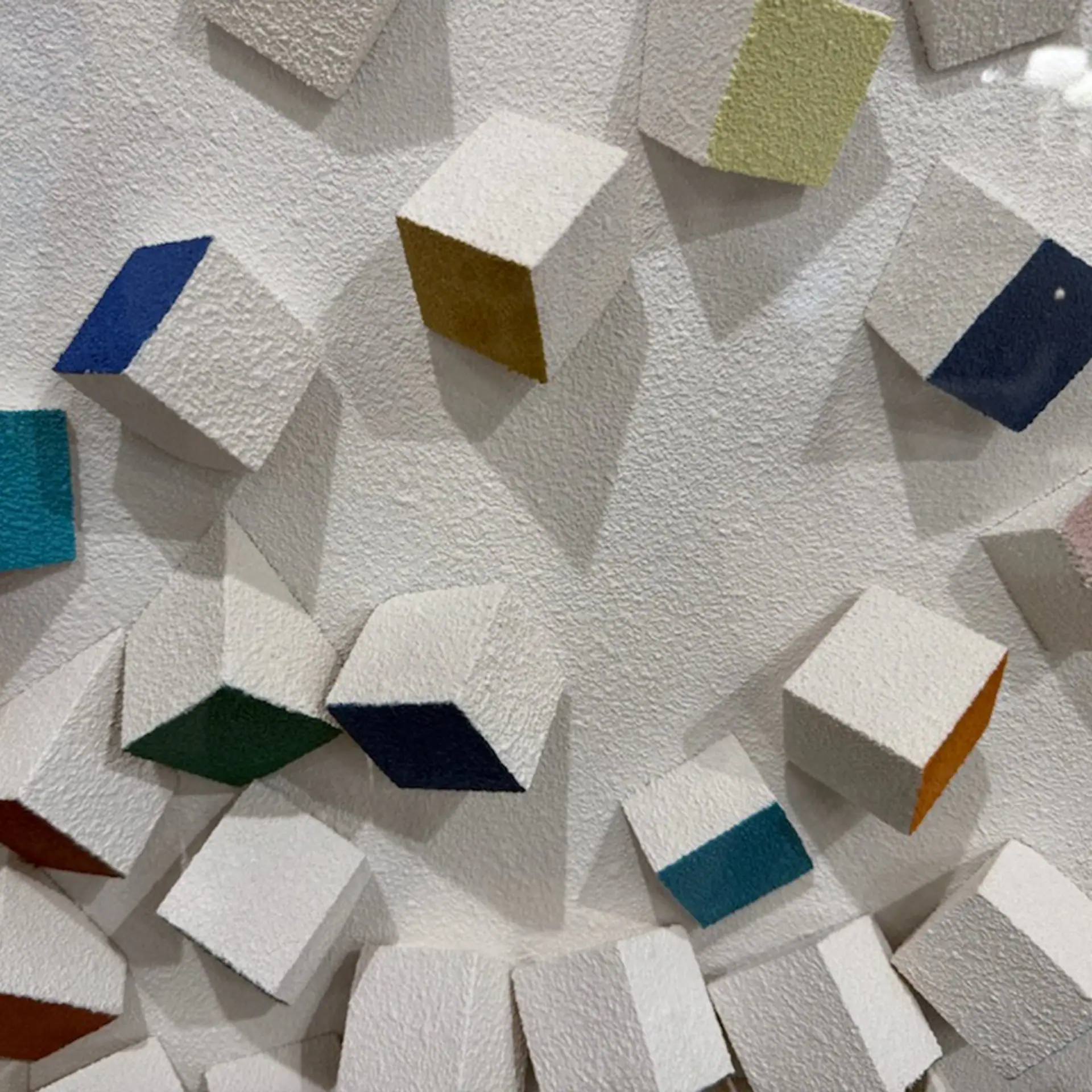 Colorful 3D wall decor featuring textured cubes in various shades on a white background.
