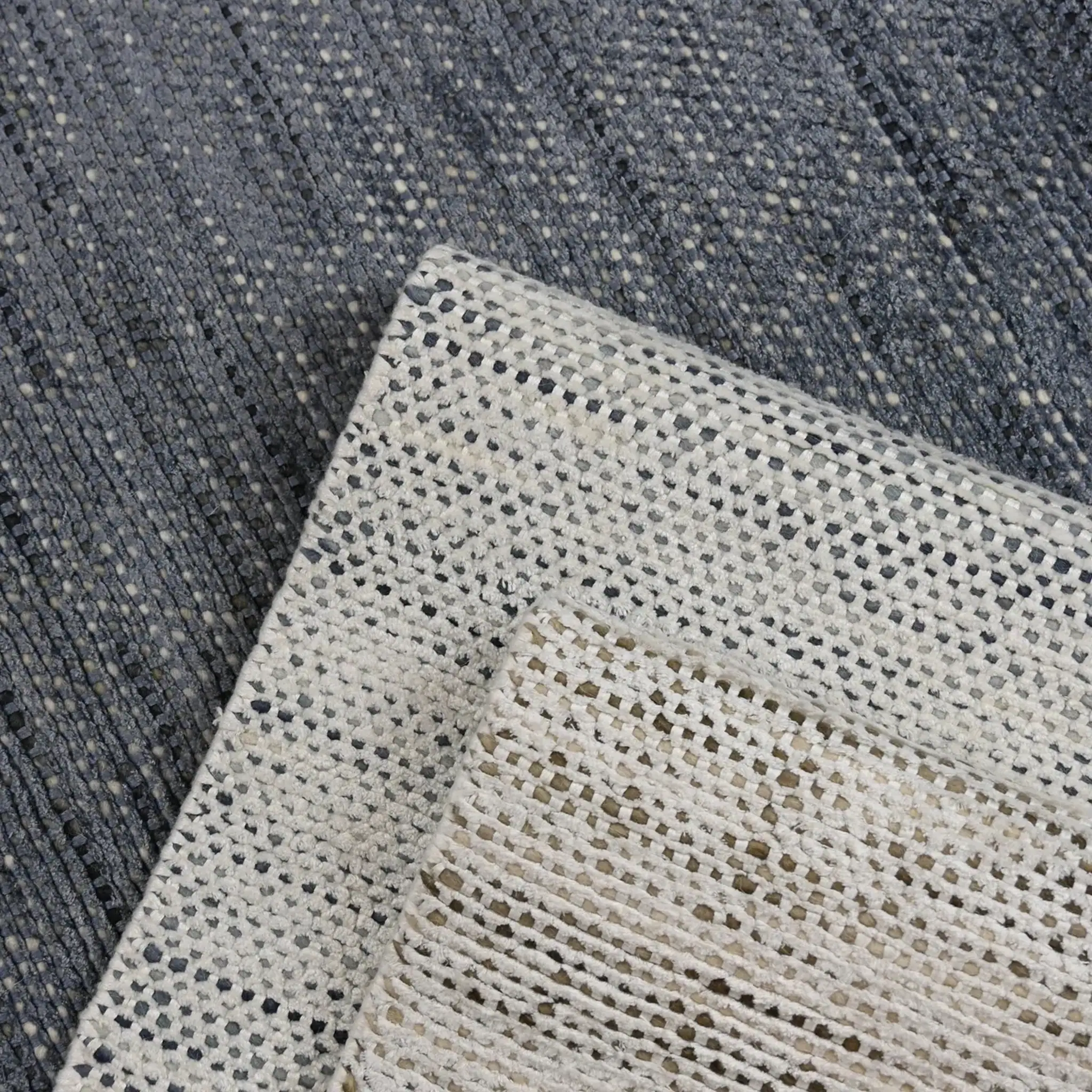 Close-up of a textured beige and gray area rug from Sklar Furnishings.