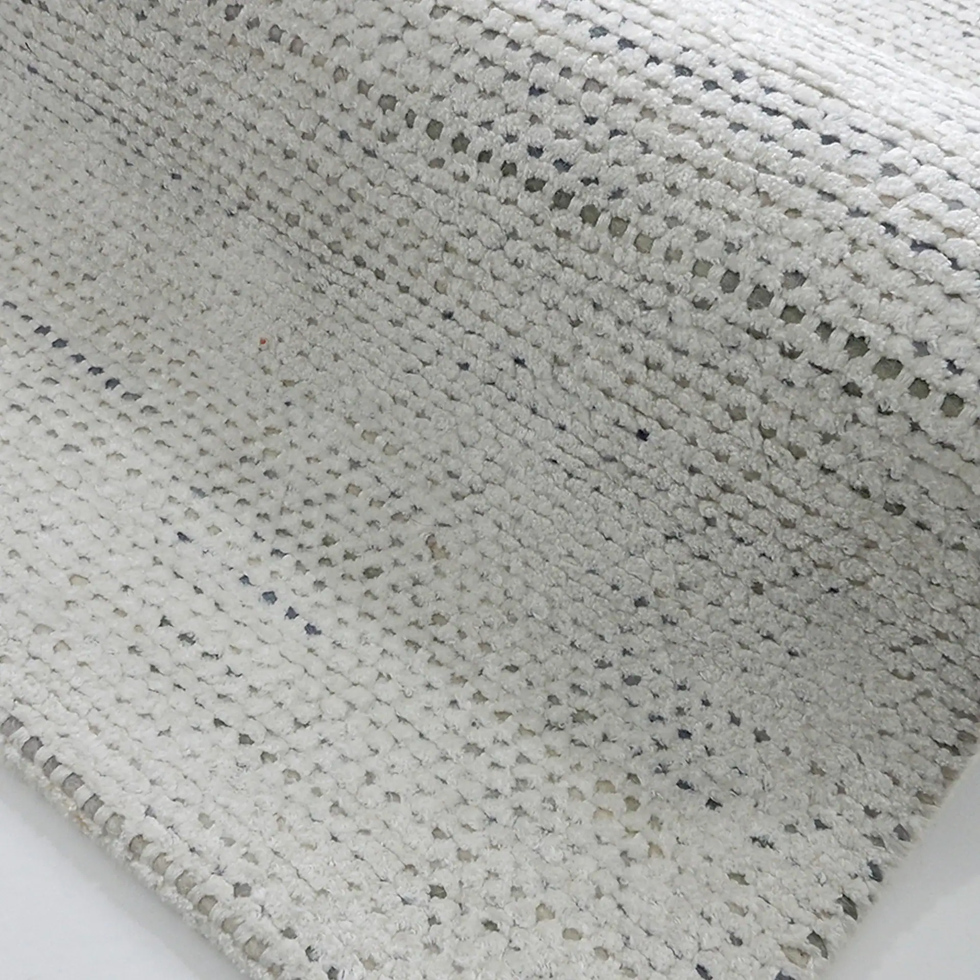 Close-up of a textured beige area rug with subtle pattern details.