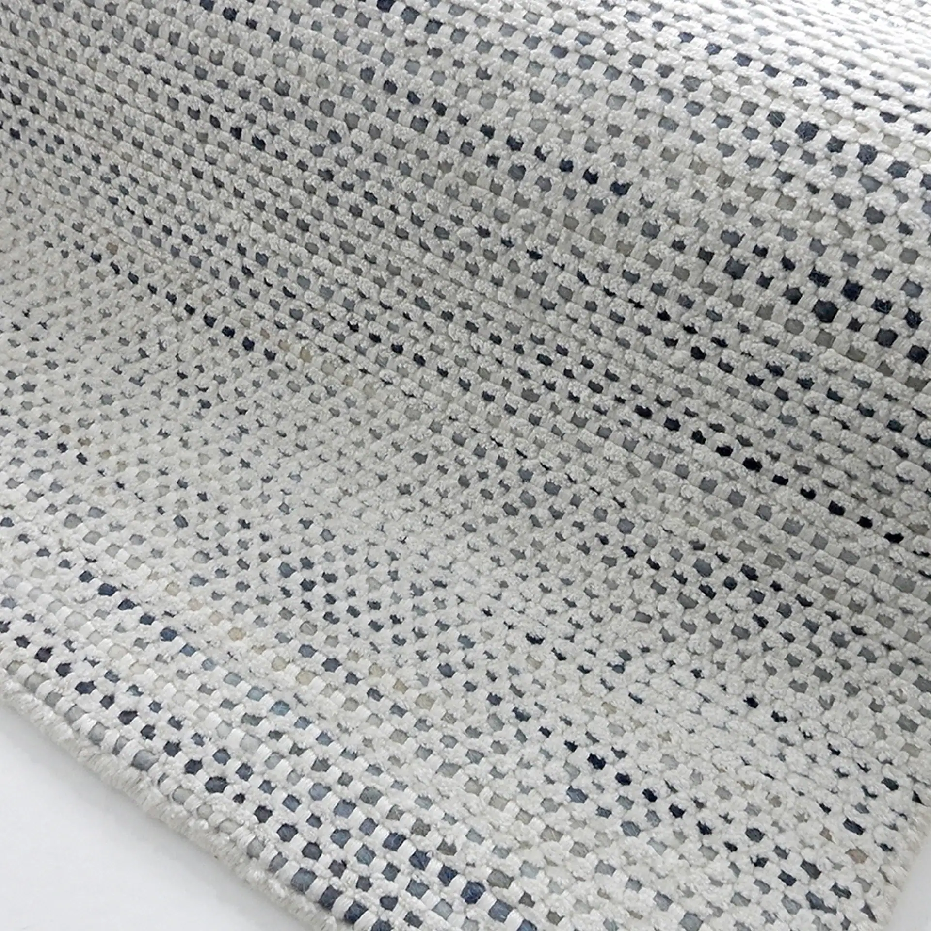 Close-up of a textured beige and black patterned area rug from Sklar Furnishings.