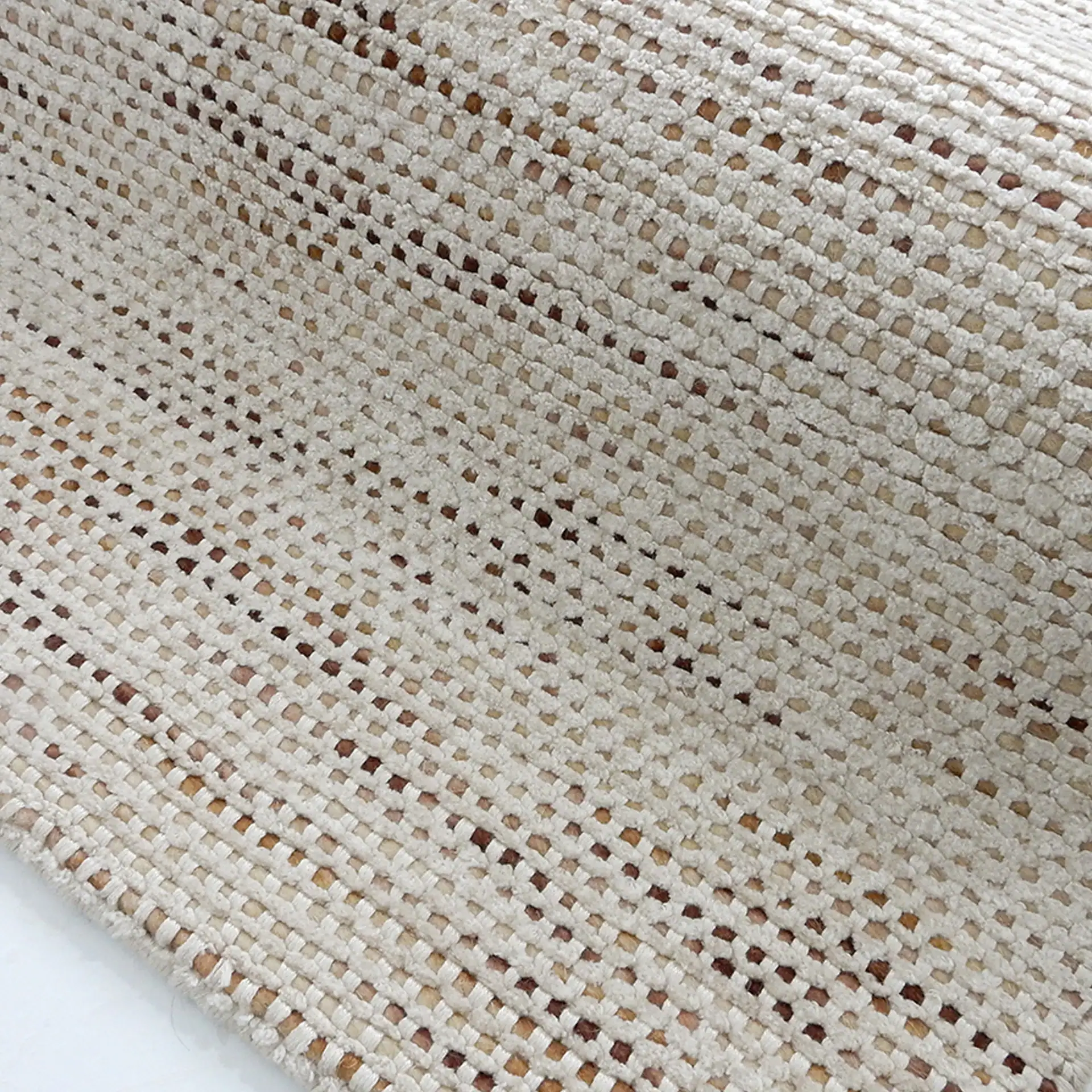 Close-up of a textured beige and brown area rug from Sklar Furnishings.