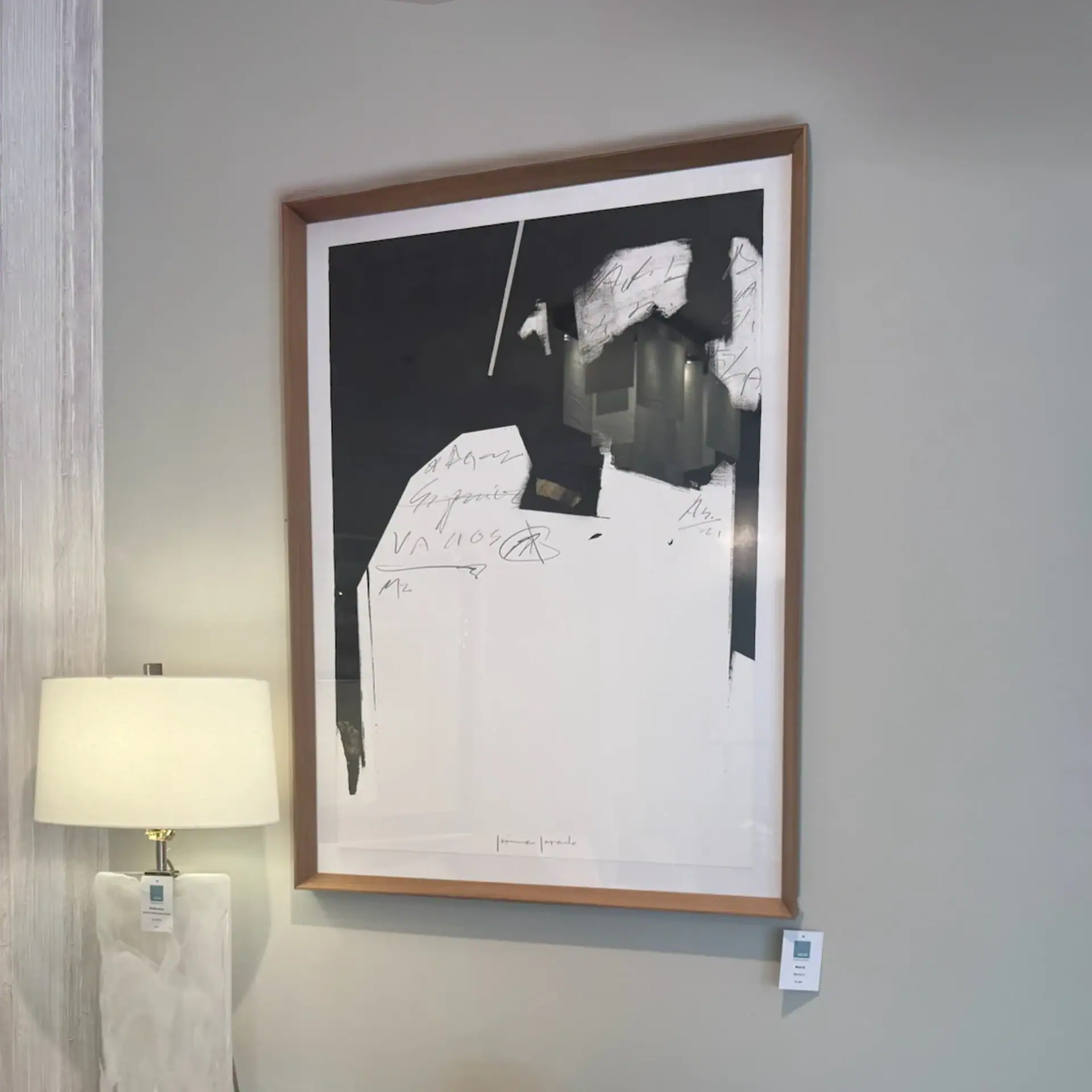 Abstract black and white paper art piece in a wooden frame.