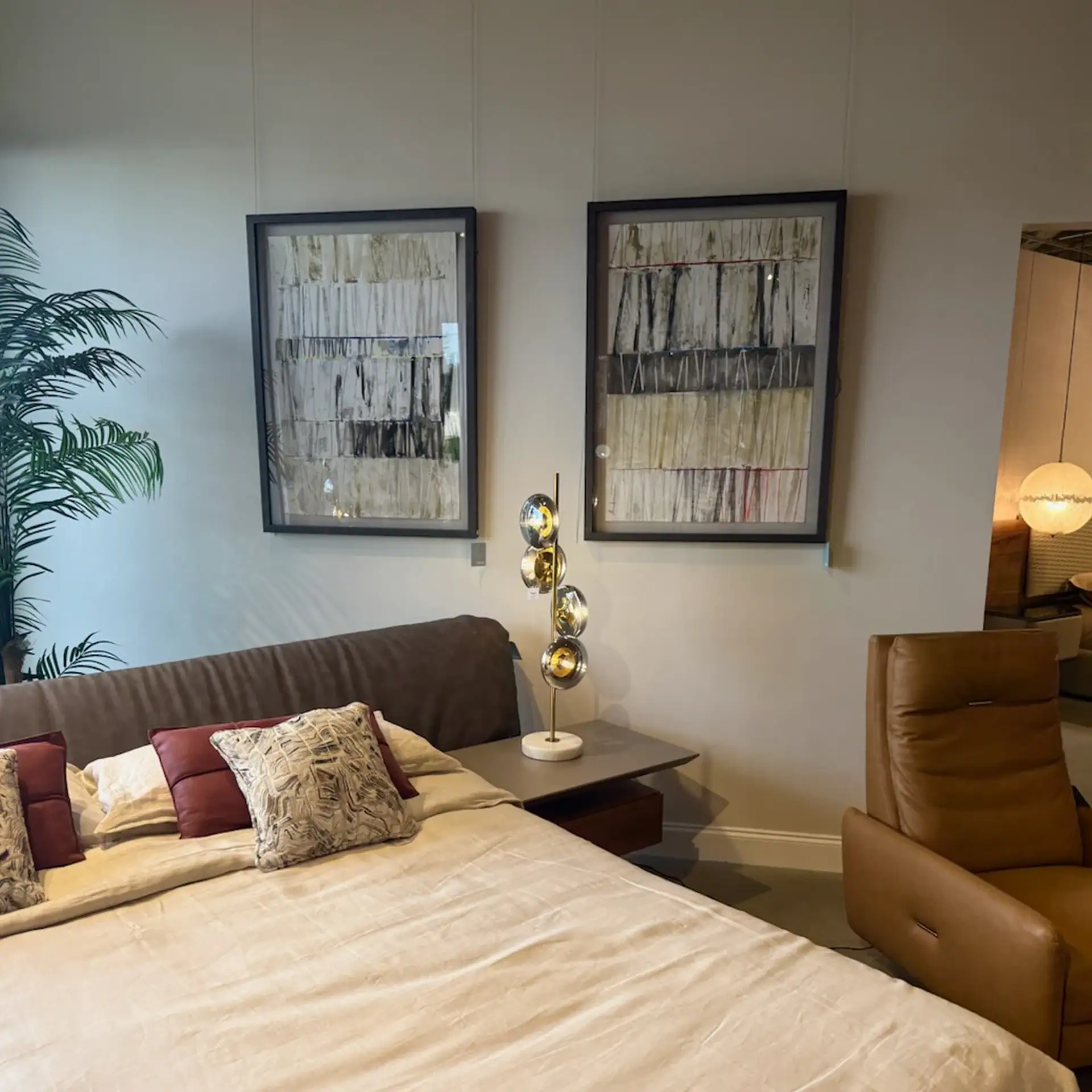 Contemporary bedroom featuring abstract wall art, plush bedding, and stylish furniture.