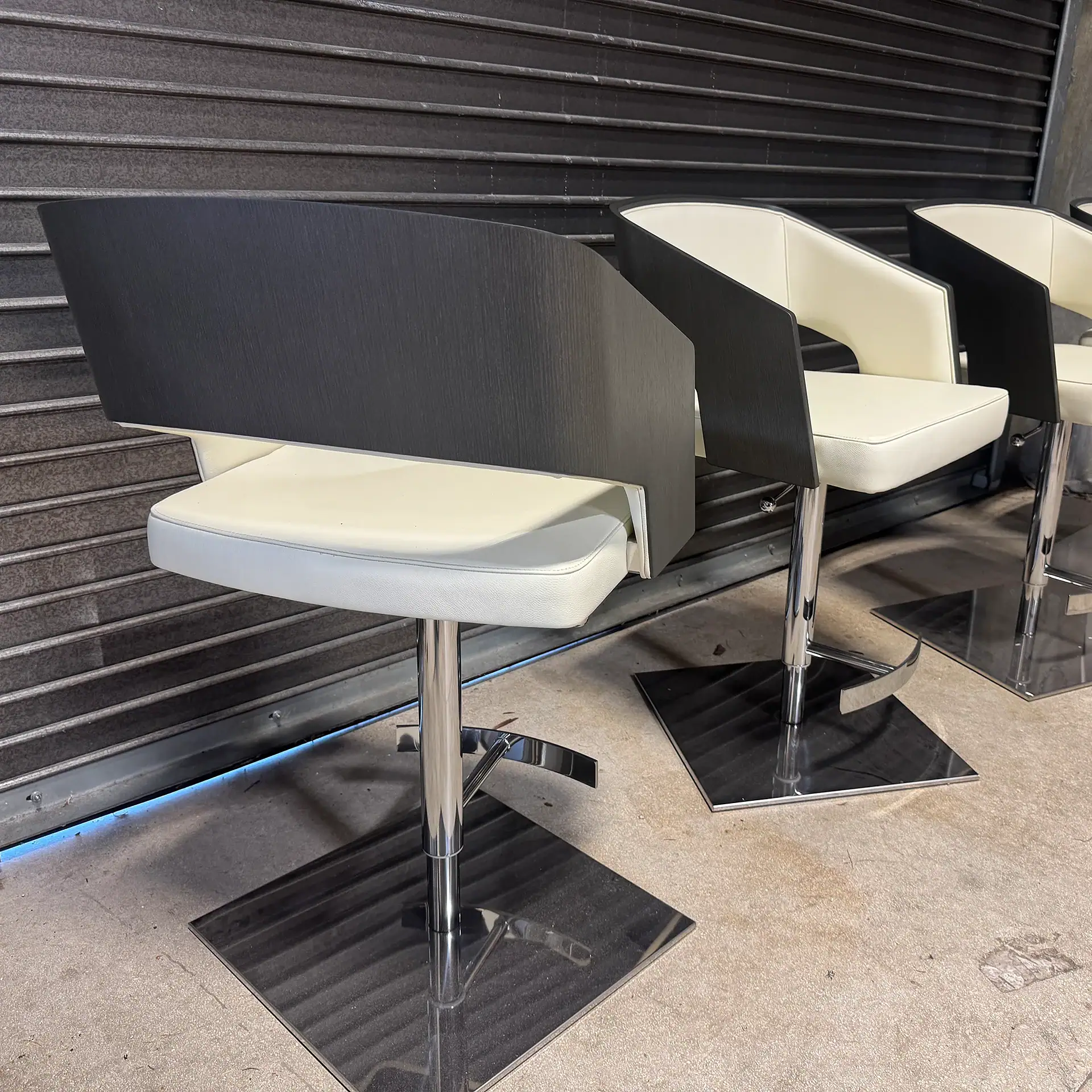 Set of stylish modern barstools with black and white design and chrome base.