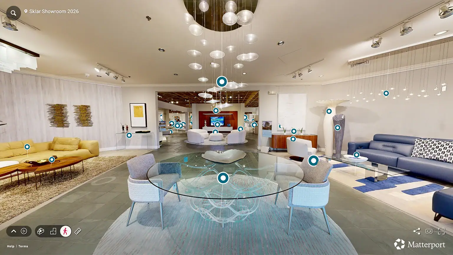 Spacious living room featuring contemporary sofas, a glass dining table, and stylish lighting fixtur.