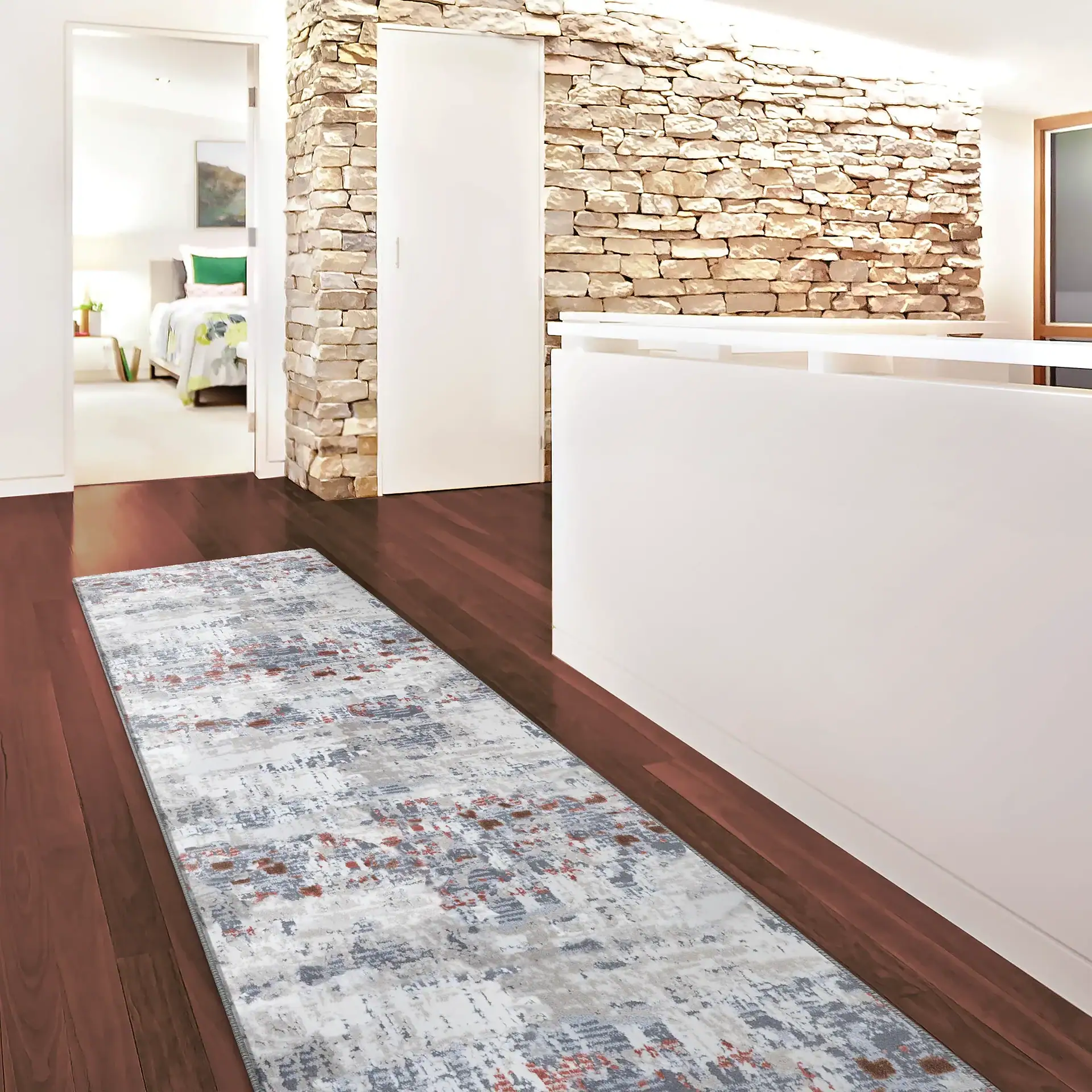 Elegant hallway featuring a stone accent wall, hardwood floors, and contemporary decor. Bright, invi.