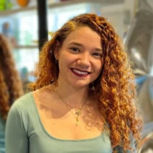 Woman with curly red hair smiling in furniture store, showcasing modern home decor.