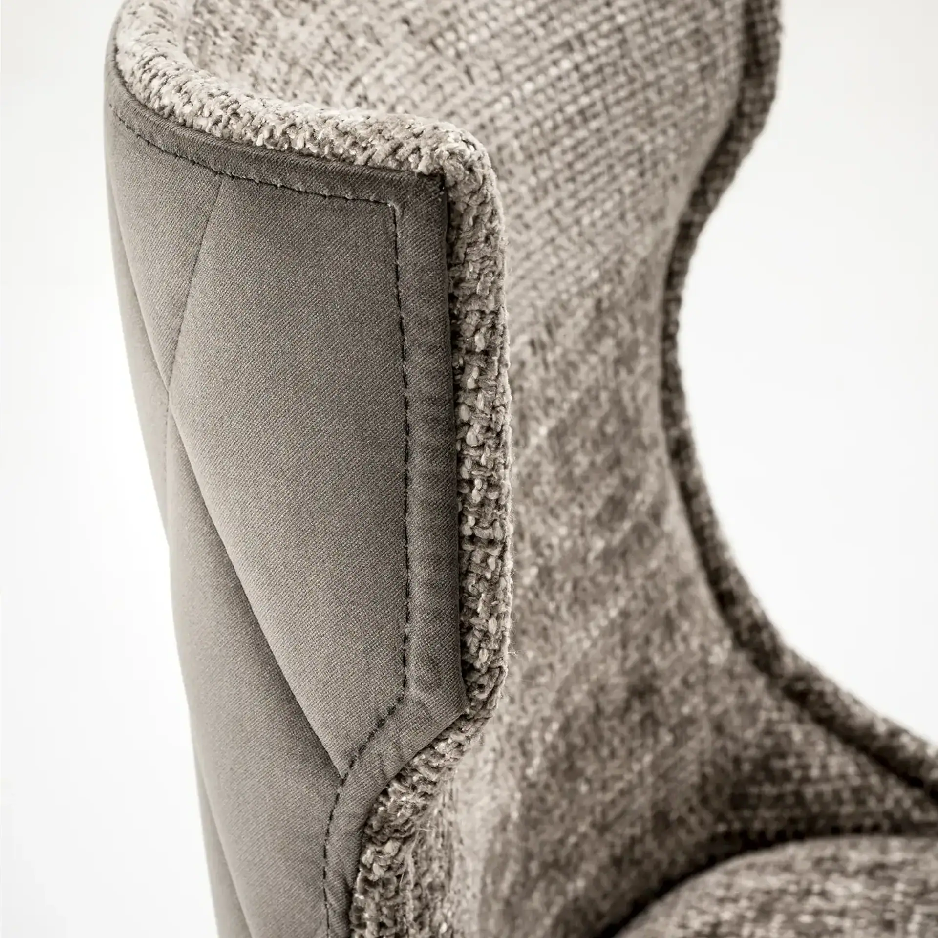 Armchair with plush fabric and detailed stitching for luxurious comfort.
