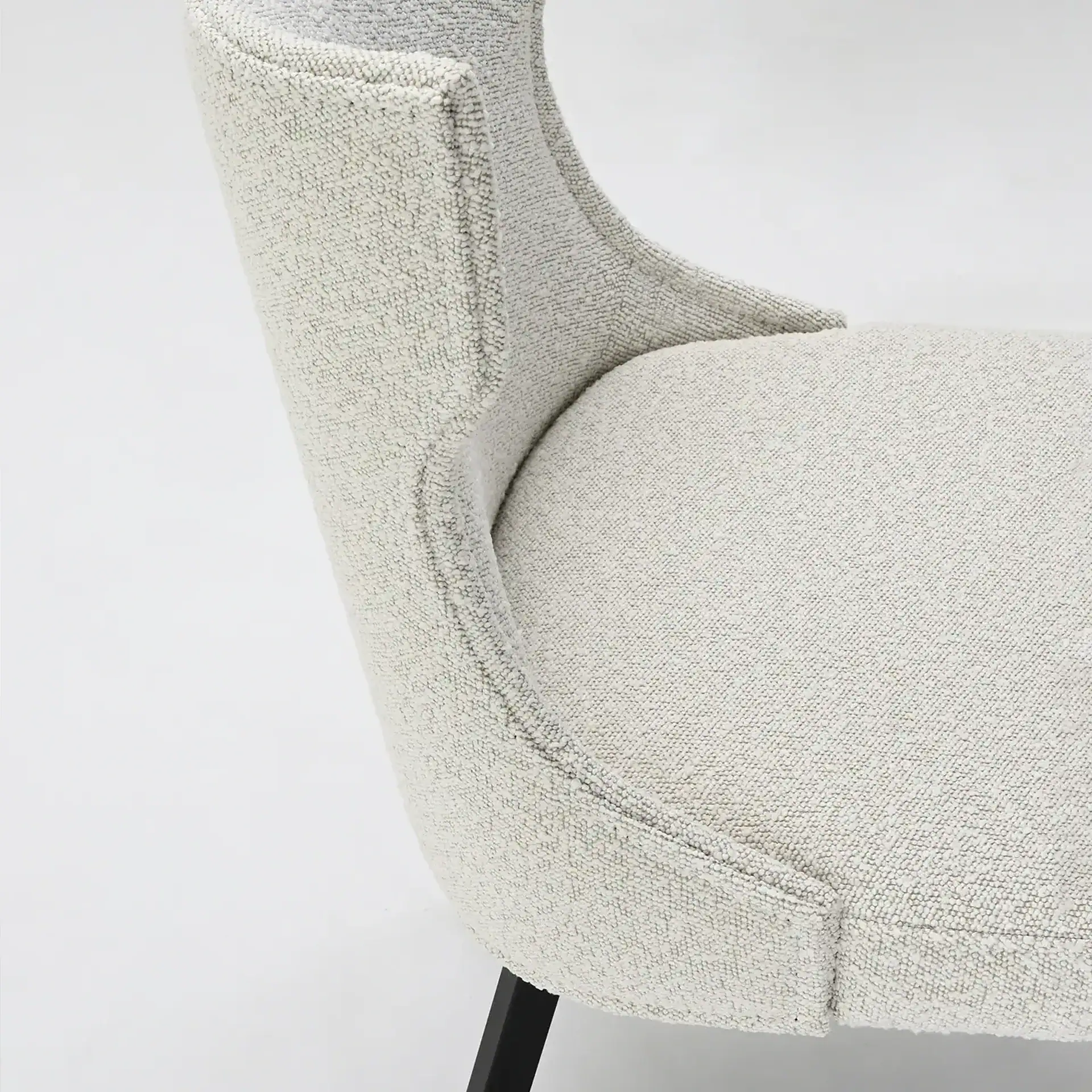 Elegant beige upholstered armchair with black wooden legs for modern living rooms.