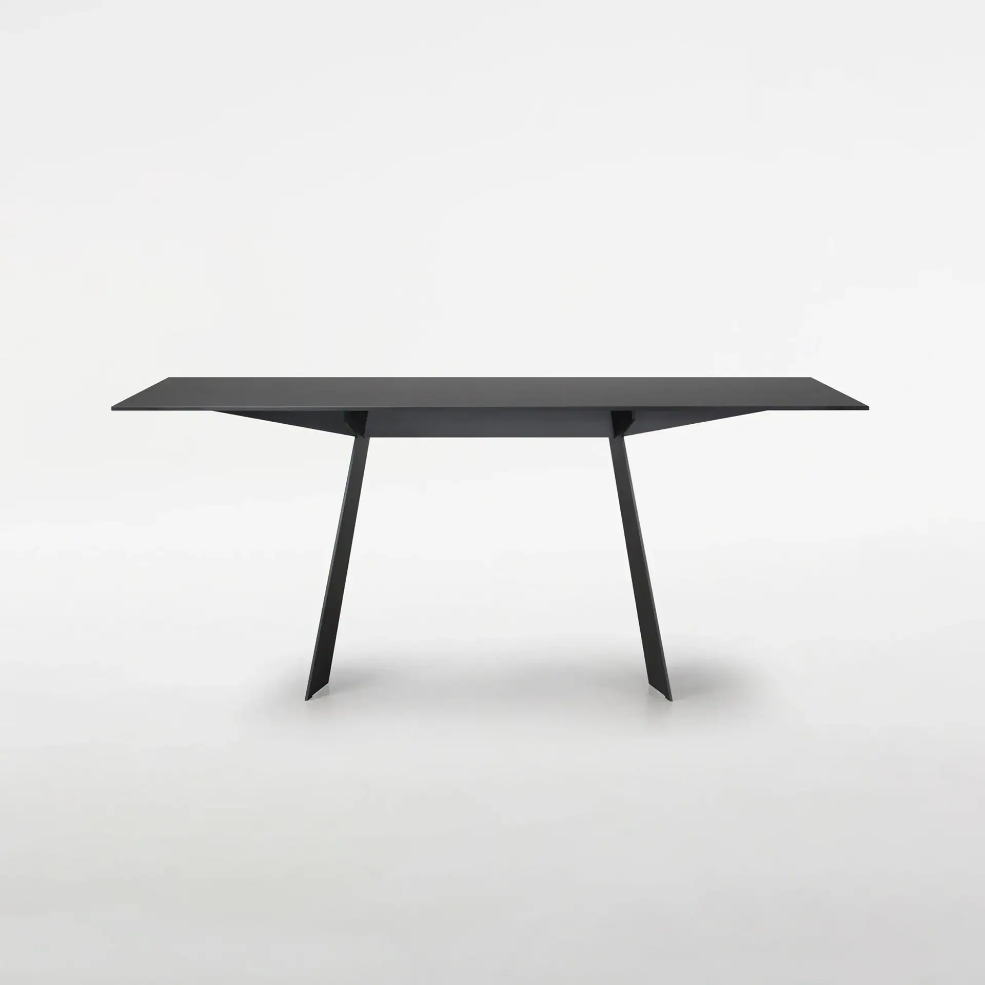 Black office desk with sleek, minimalist design and angled legs, ideal for contemporary workspaces.