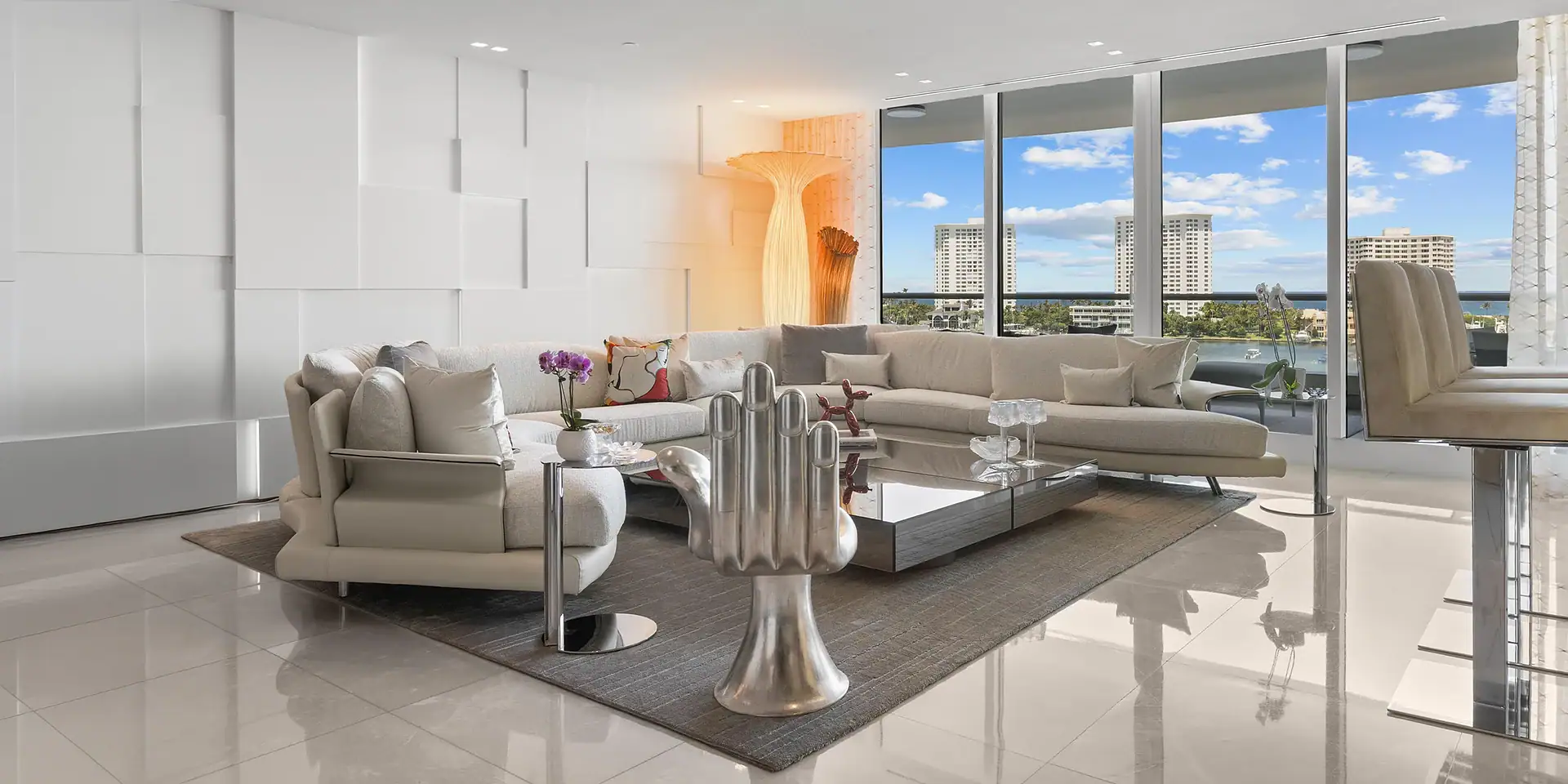 Spacious waterfront living room with large windows and contemporary furniture.