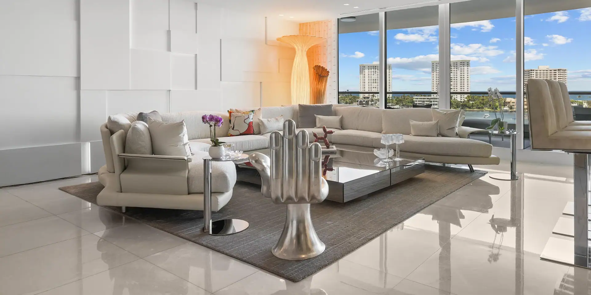 Spacious waterfront living room with large windows and contemporary furniture.