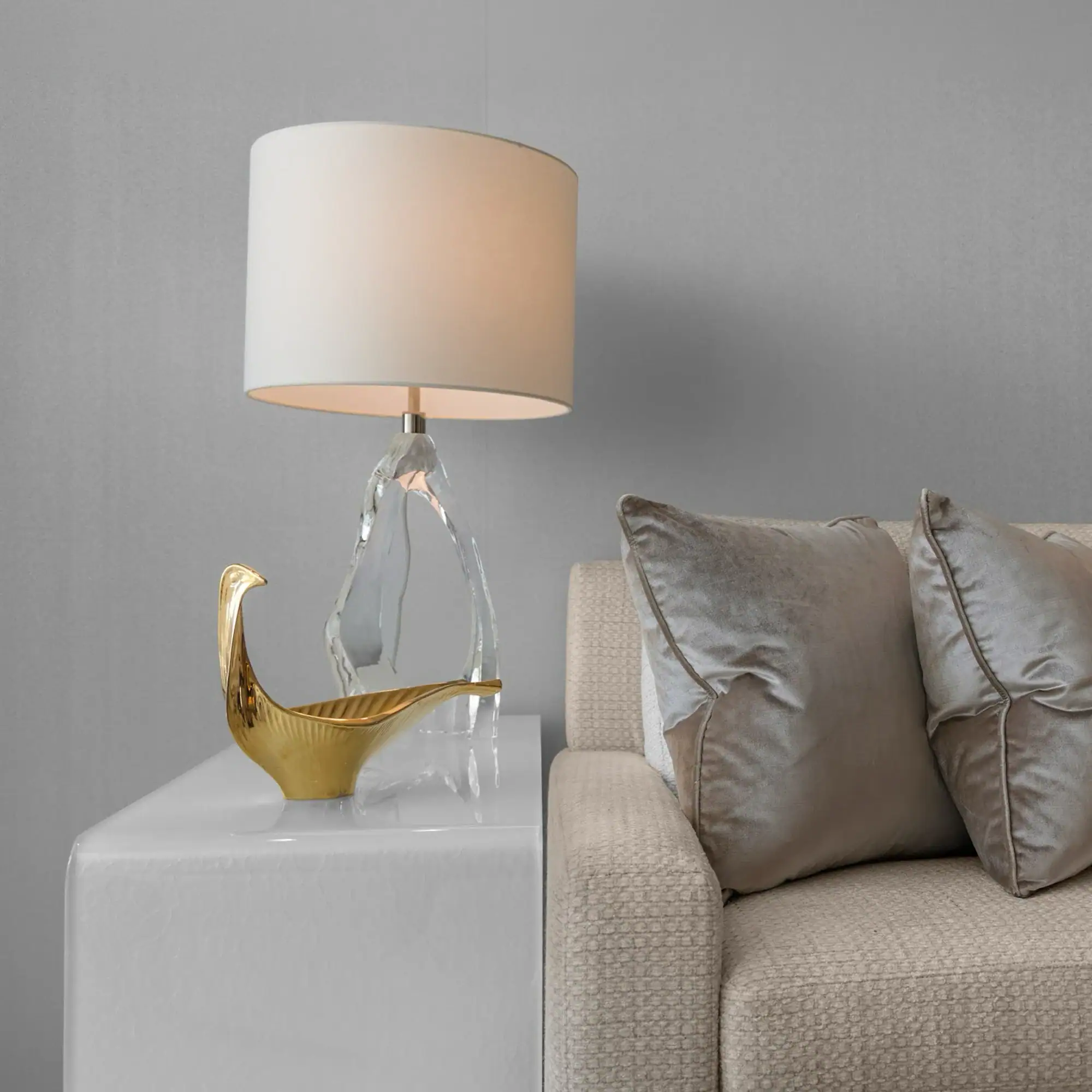 Elegant Table Lamp by Sklar Furnishings Sklar Furnishings table lamp with glass and gold design next to sofa.