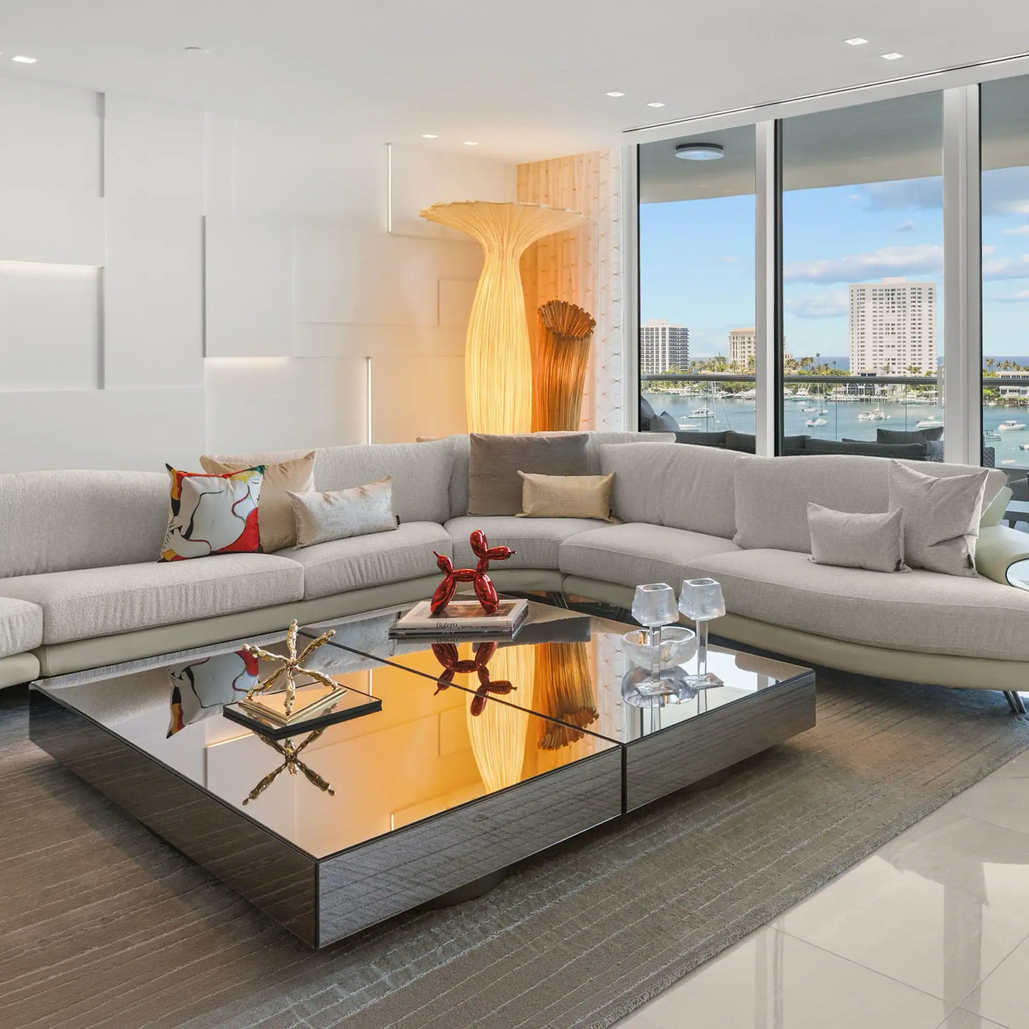 Modern Waterfront Living Room Spacious living room with large windows overlooking water and cityscape.