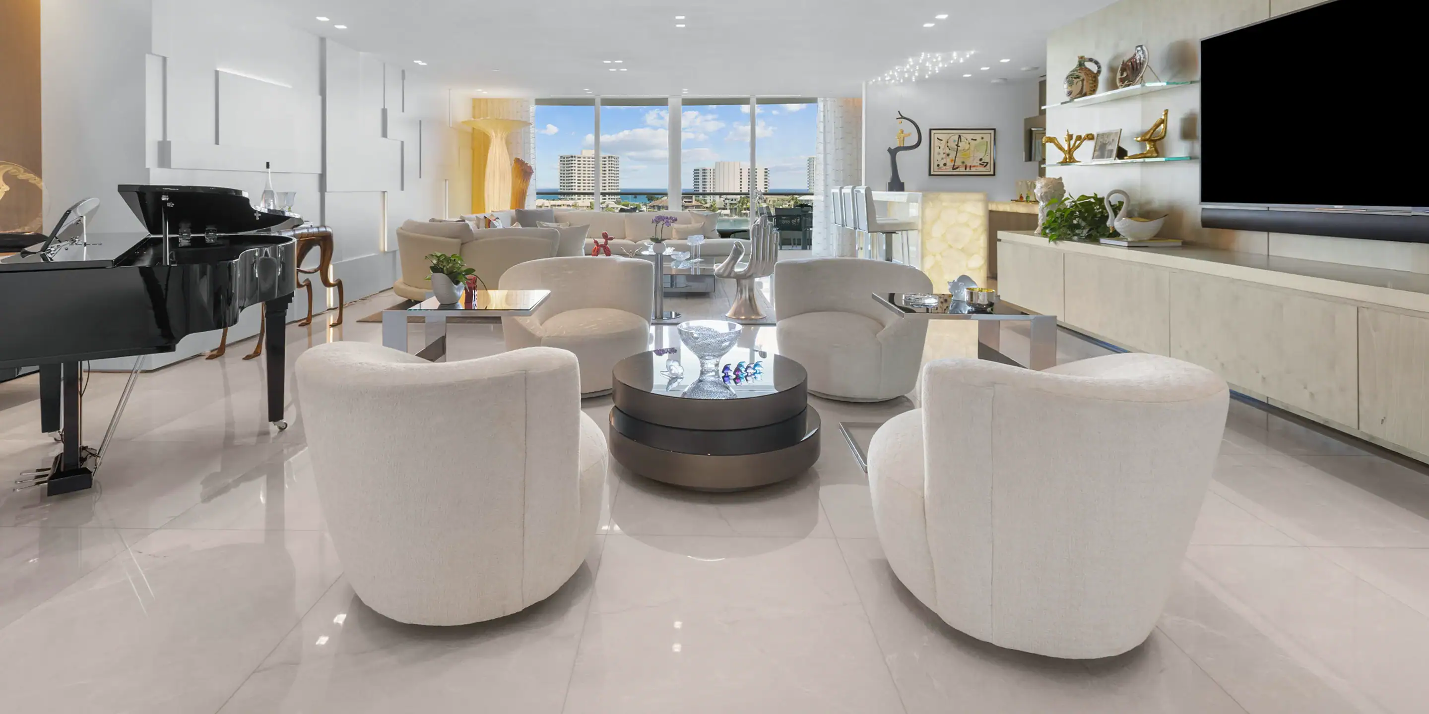 Modern Waterfront Living Room Spacious living room with white chairs and large windows overlooking water.