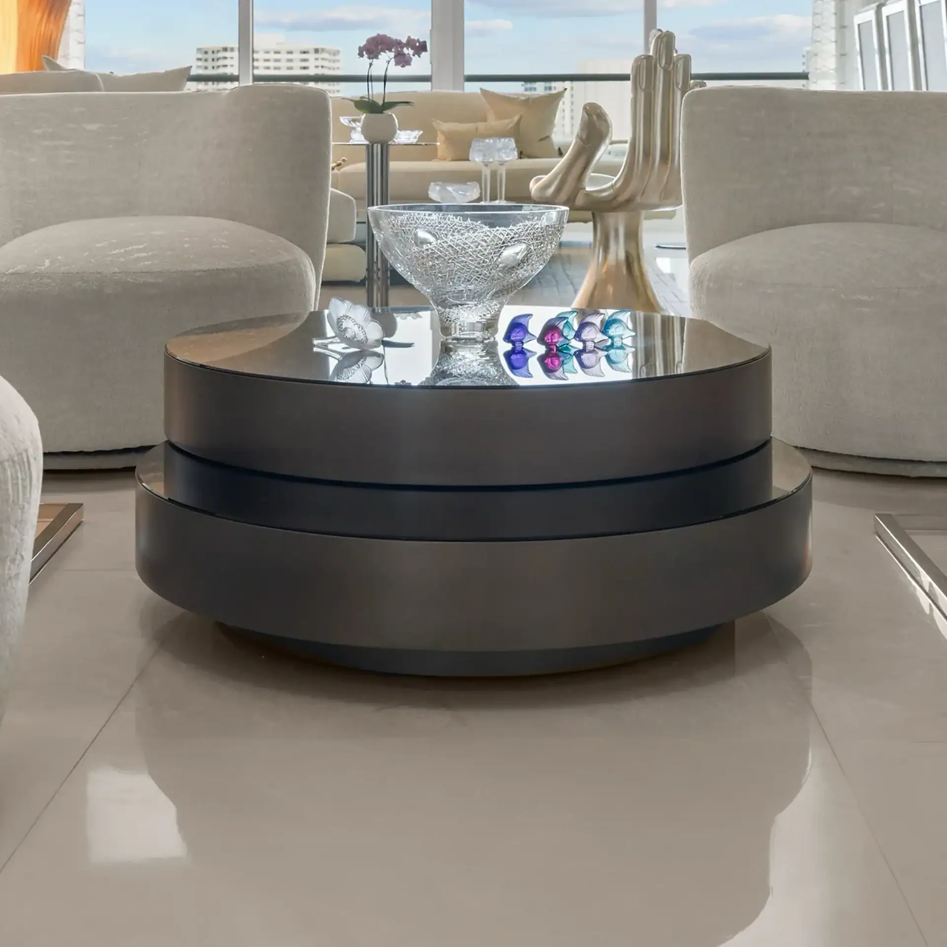 Modern black coffee table with glass bowl in a bright living room.