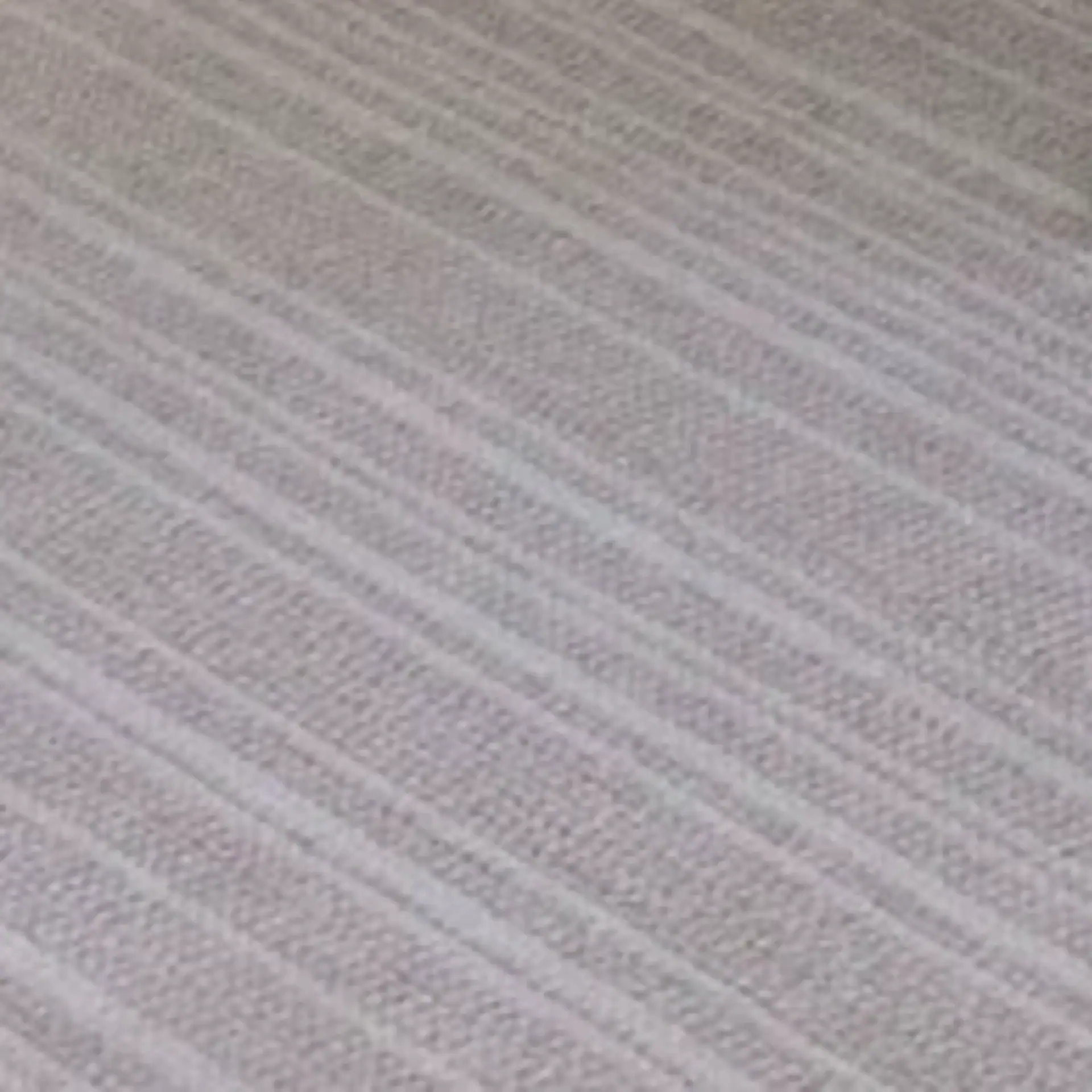 Close-up of textured fabric with diagonal lines and woven pattern.