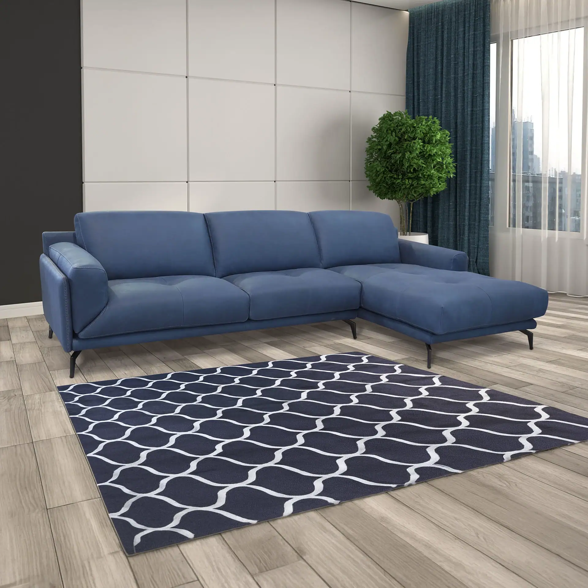 A modern living room with a blue sectional sofa, a dark blue and white patterned rug, a potted plant, and a window with city views.