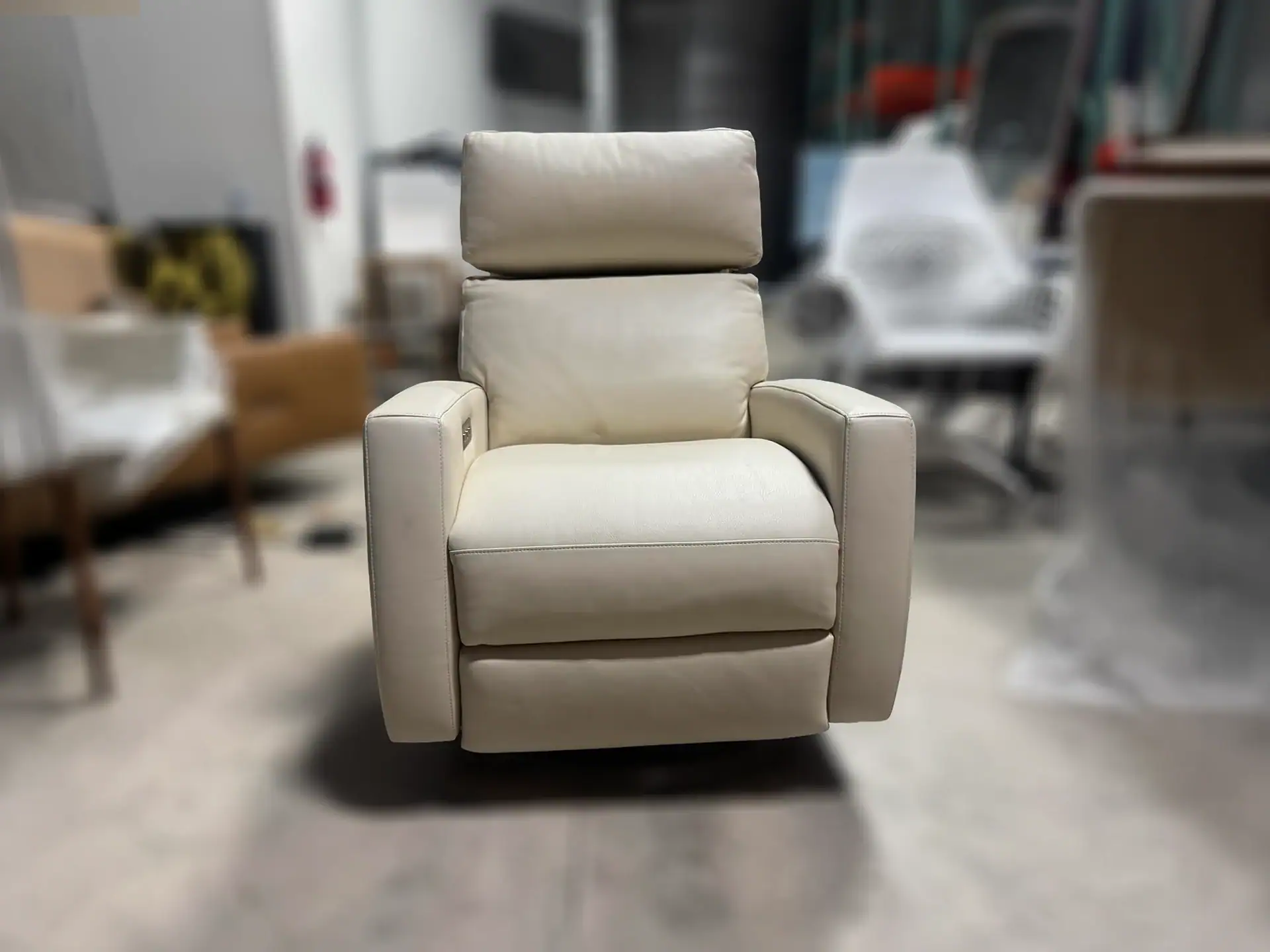 American Leather Demi Recliner in cream color in a warehouse setting.