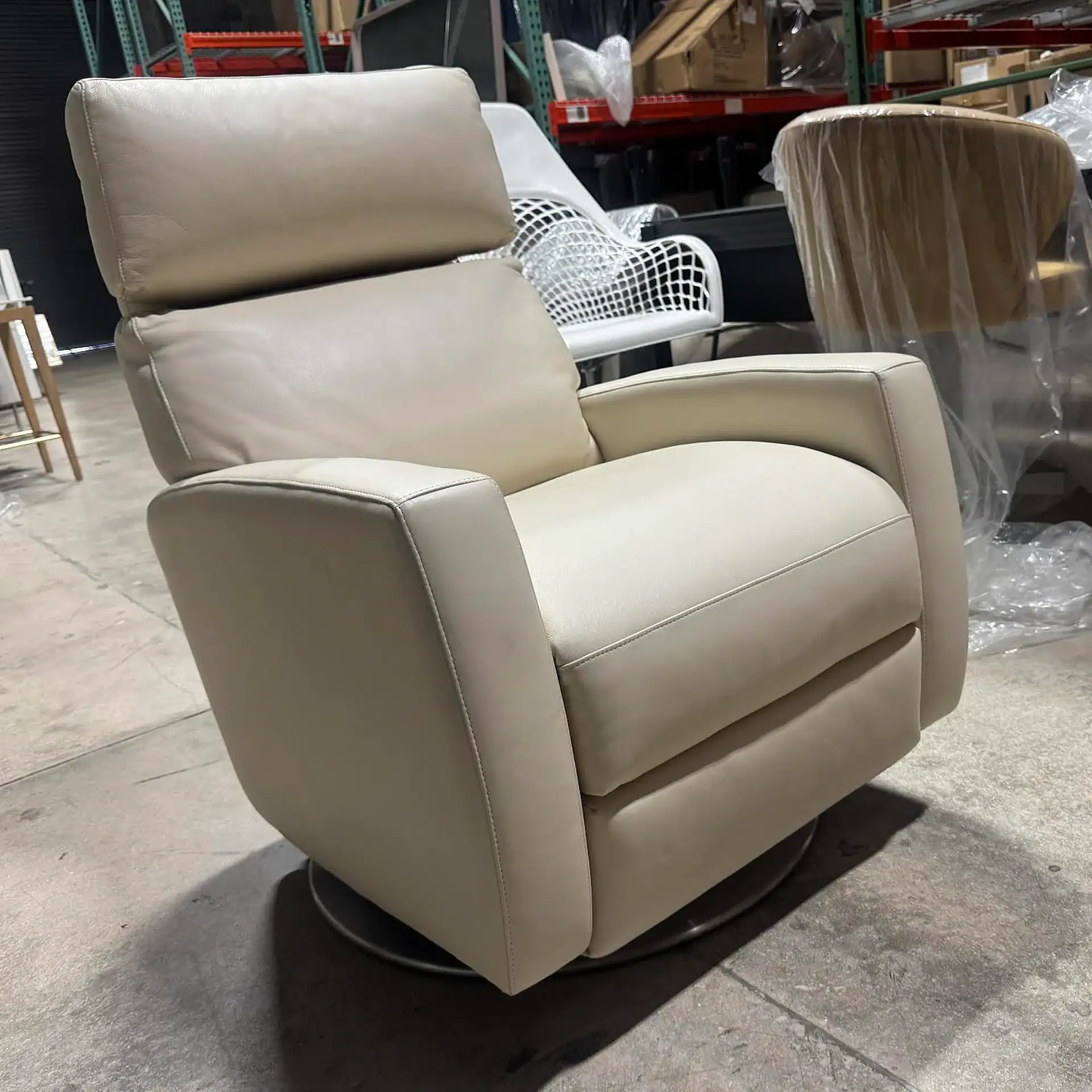 Sklar Furnishings recliner in beige with headrest and armrests.