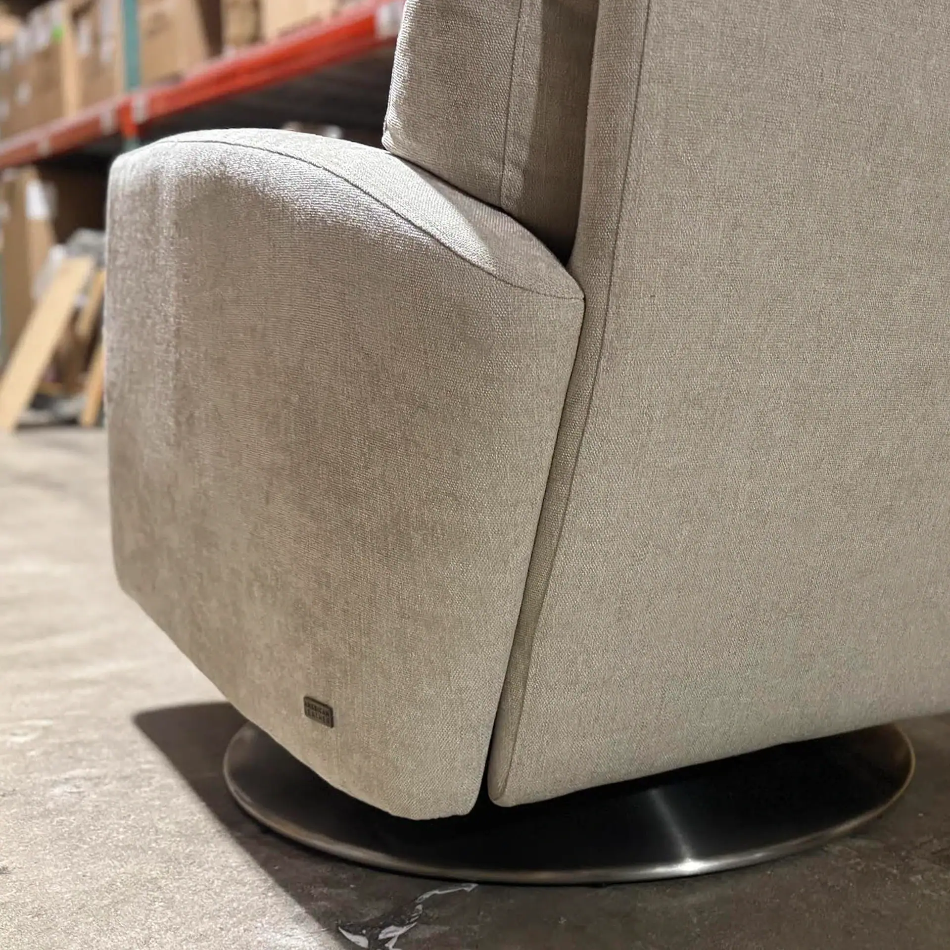 American Leather Elliot Recliner in beige fabric with black swivel base.