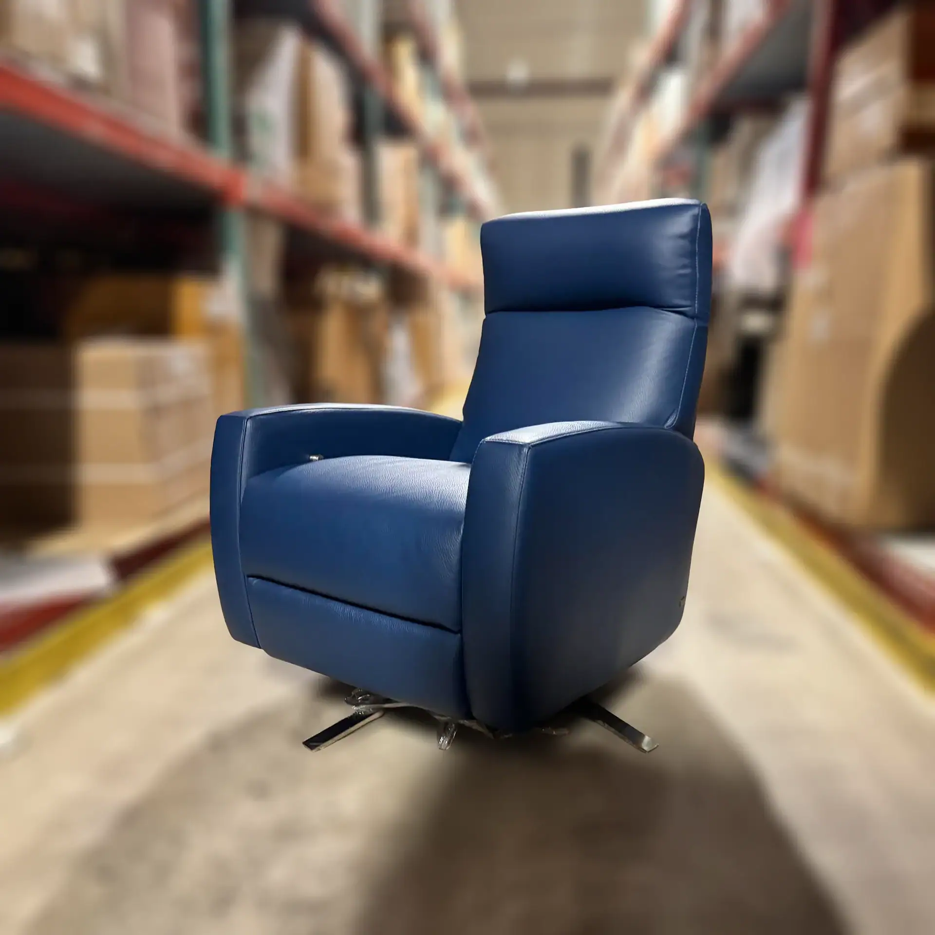 Sklar Furnishings blue recliner in warehouse setting.