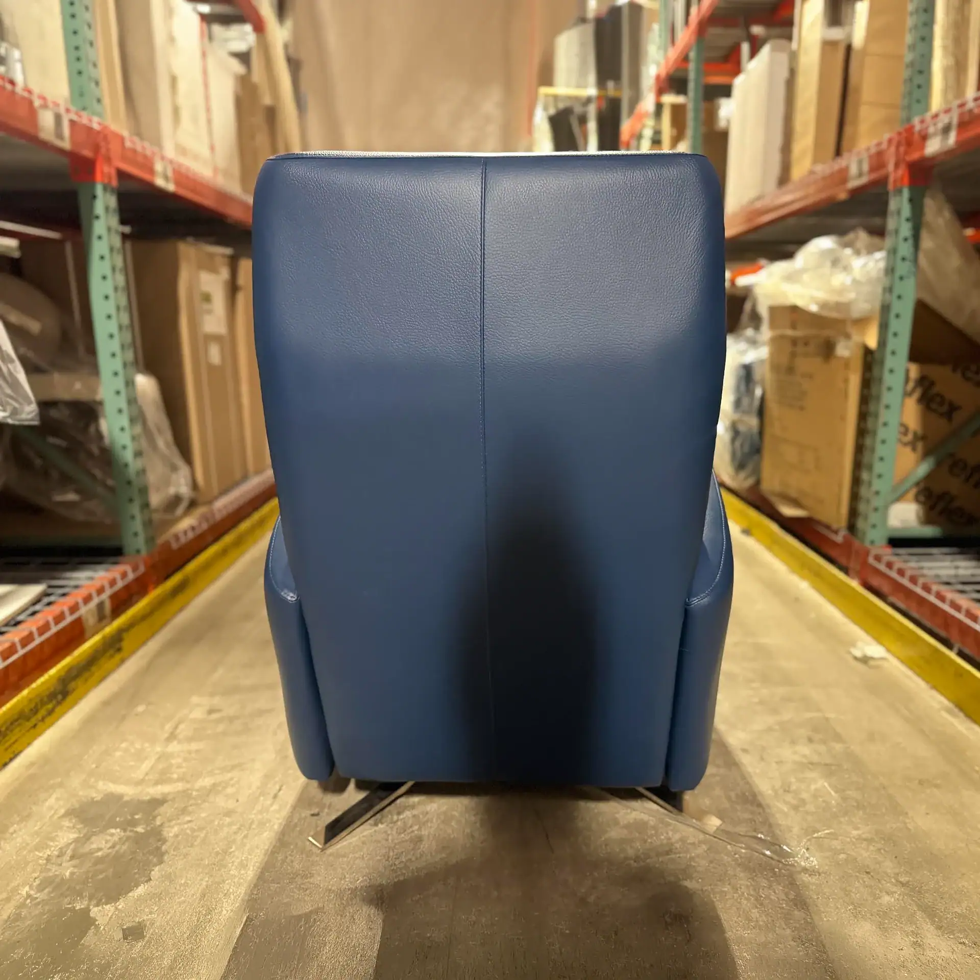 Sklar Furnishings blue recliner in warehouse aisle.