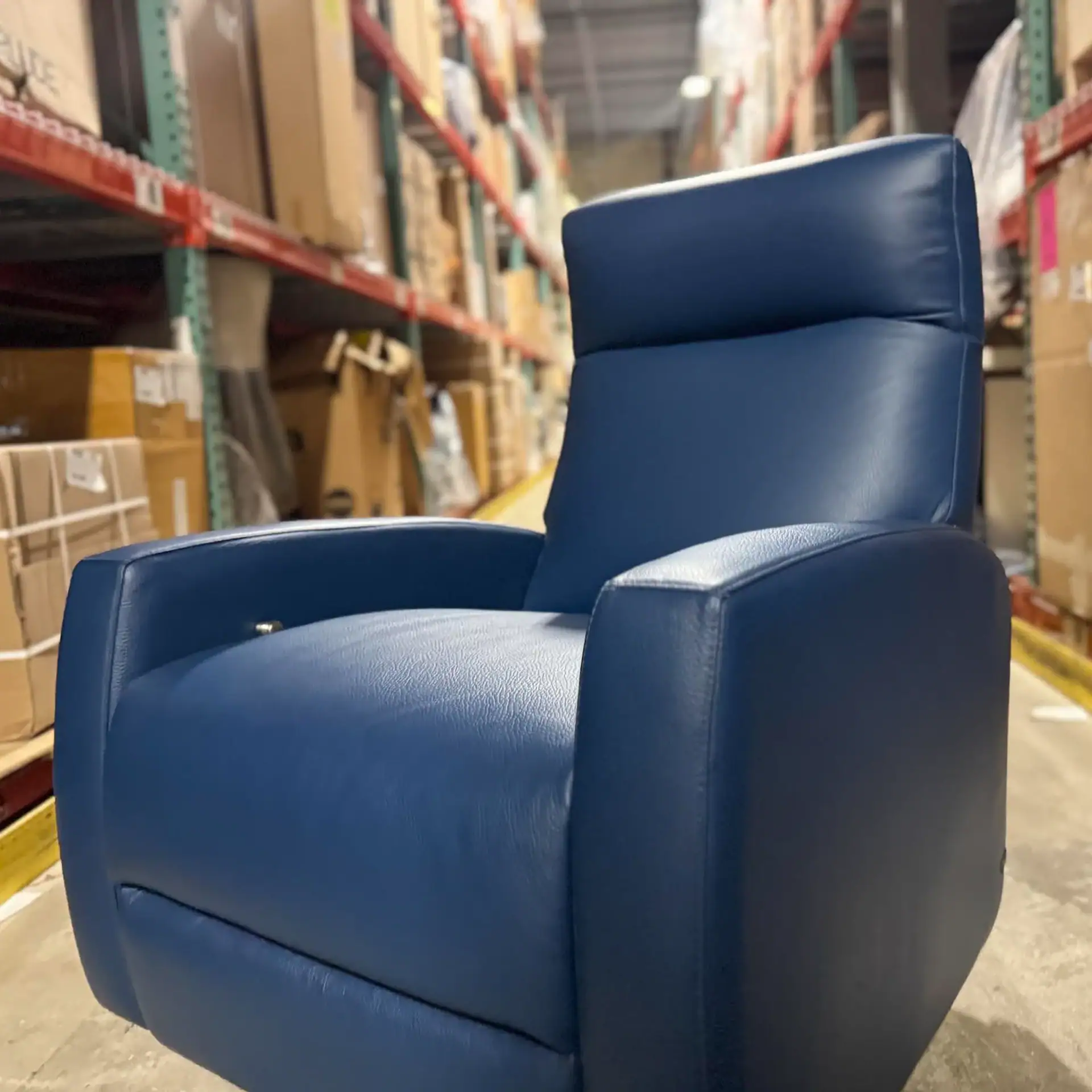 Sklar Furnishings blue recliner in warehouse aisle.