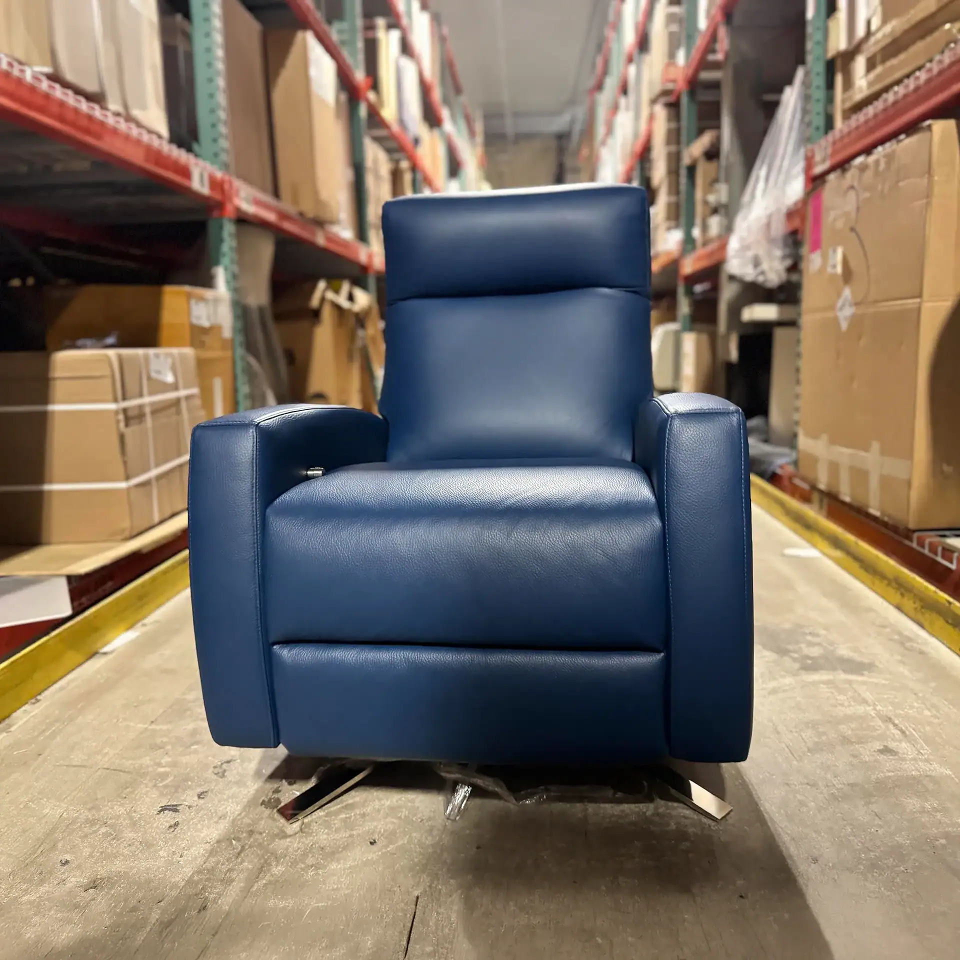 Sklar Furnishings blue recliner in warehouse aisle.