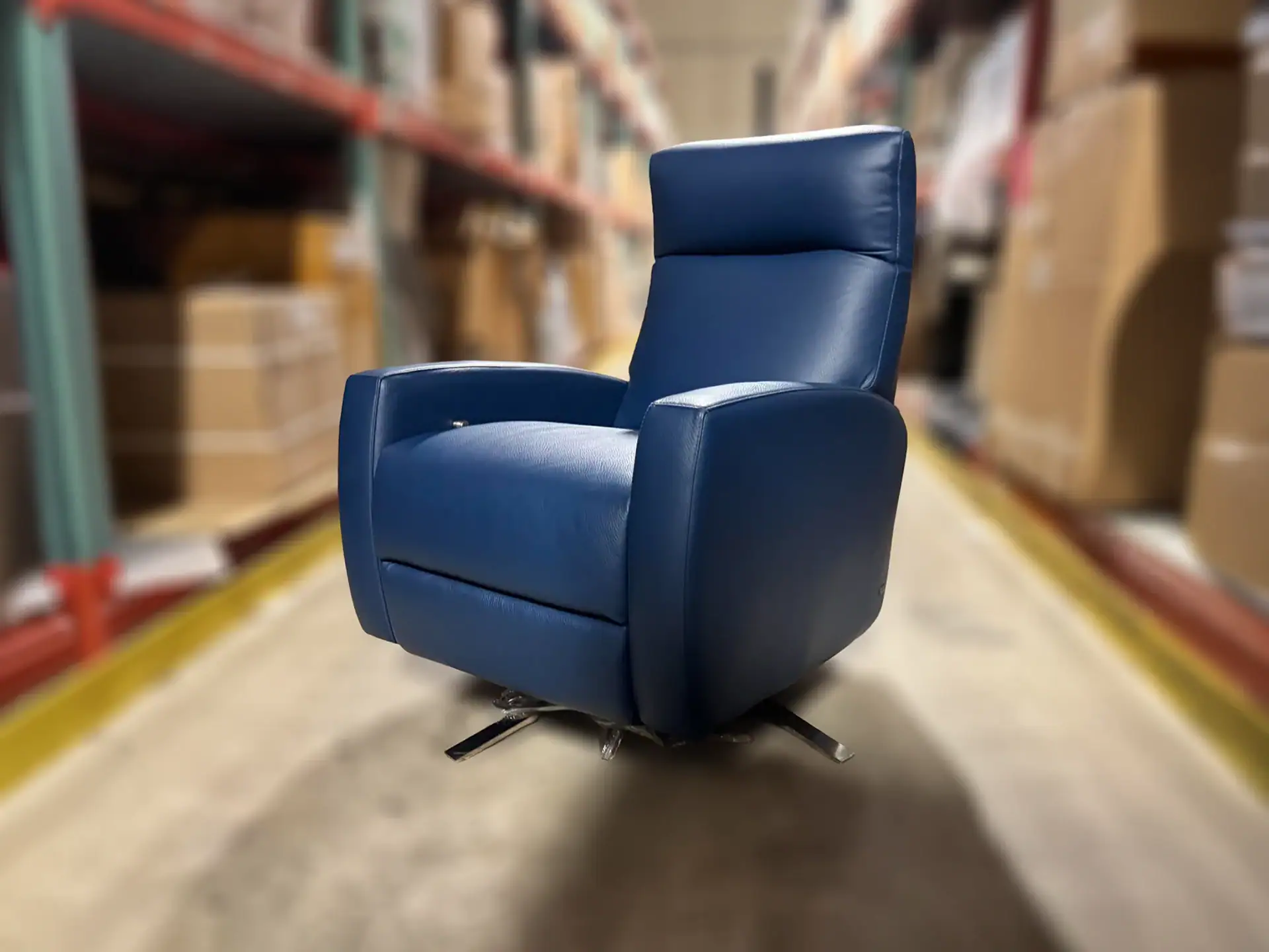 American Leather Eva Comfort Recliner in blue in warehouse setting.