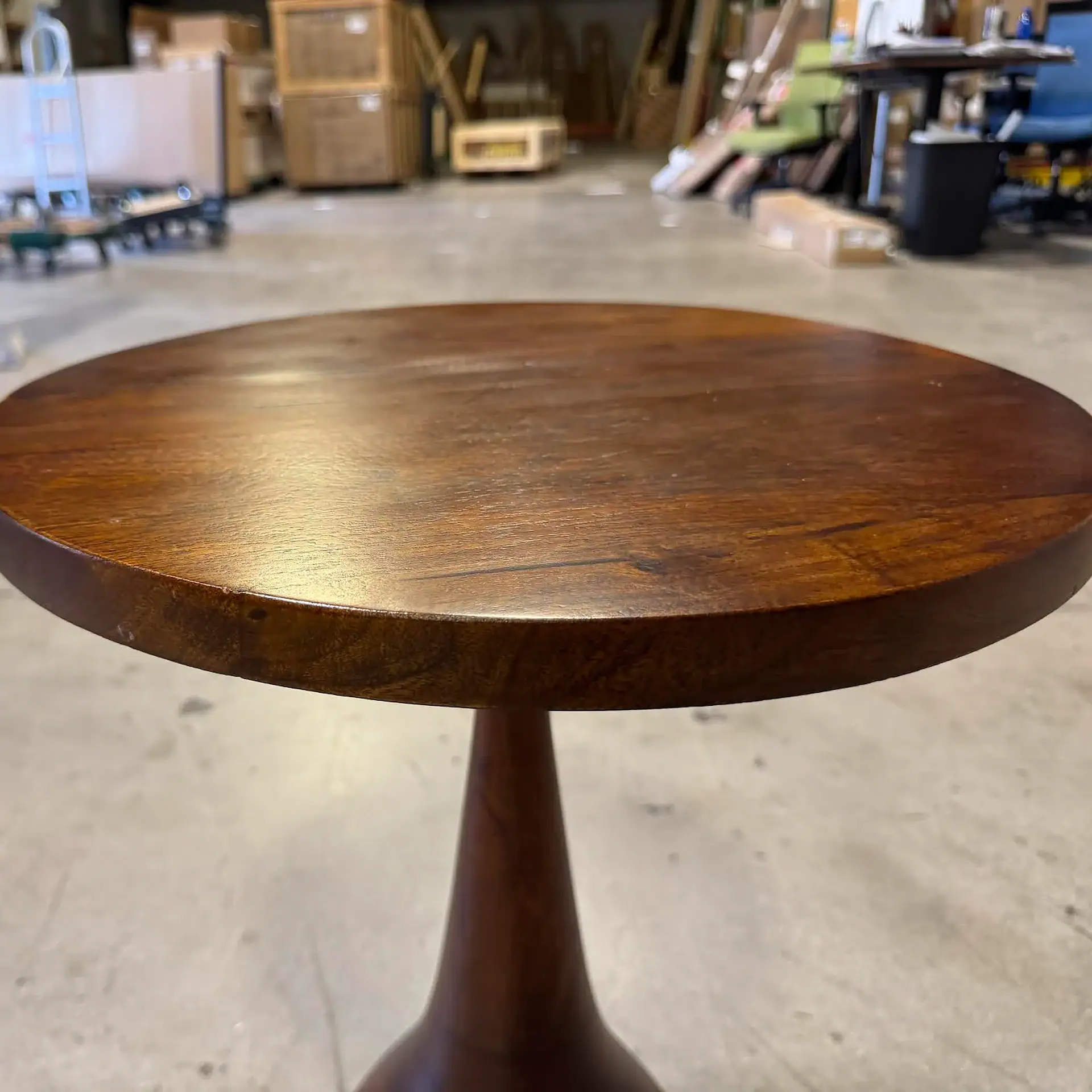 Sklar Furnishings wooden accent table in warehouse setting.
