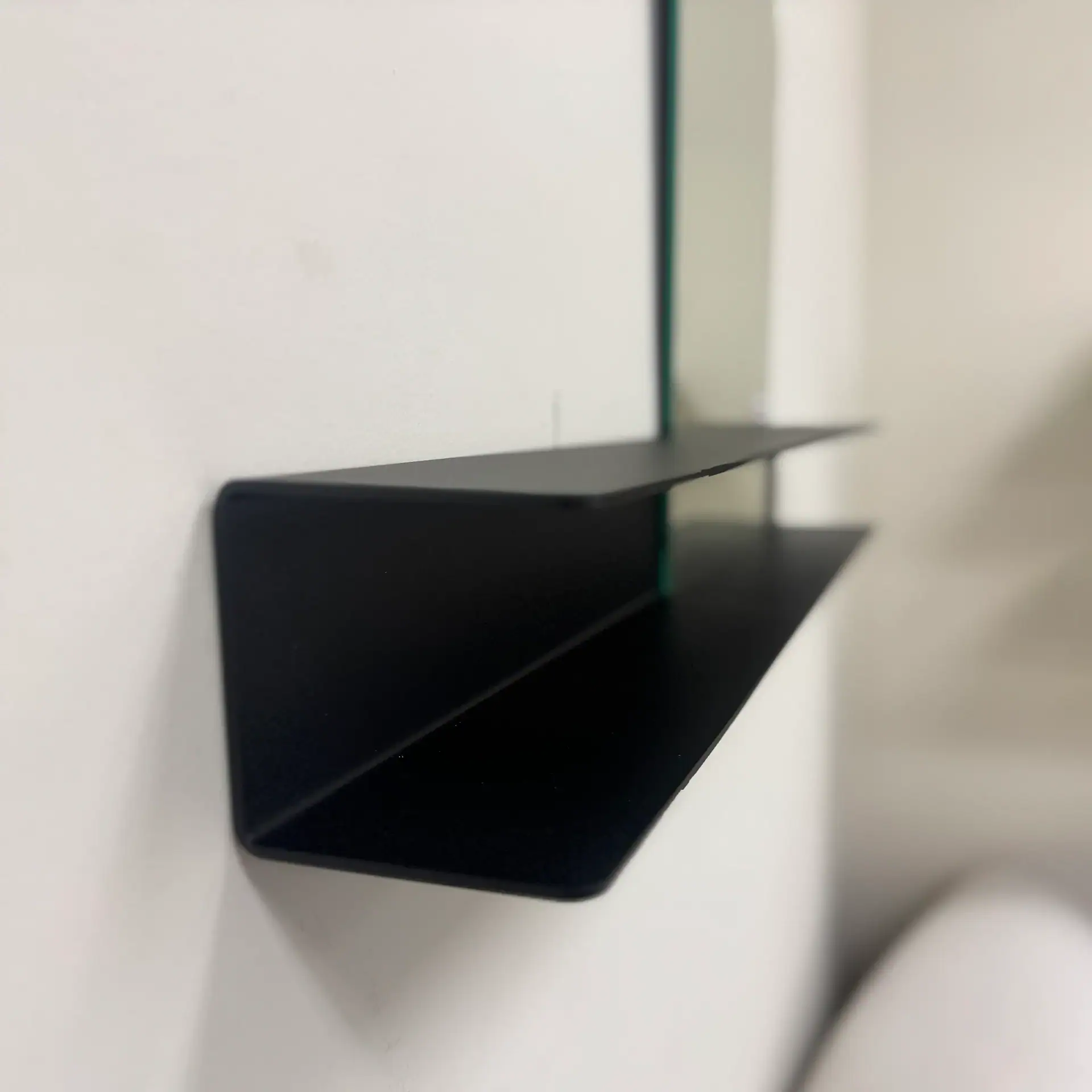 Modern black wall shelf for home decor and storage.